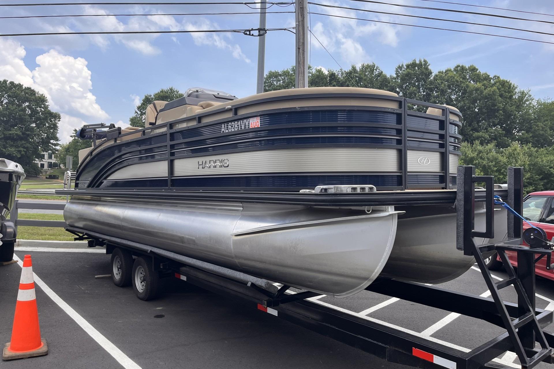 2022 Harris Solstice 230 CWDH pontoon boat on trailer in parking lot.