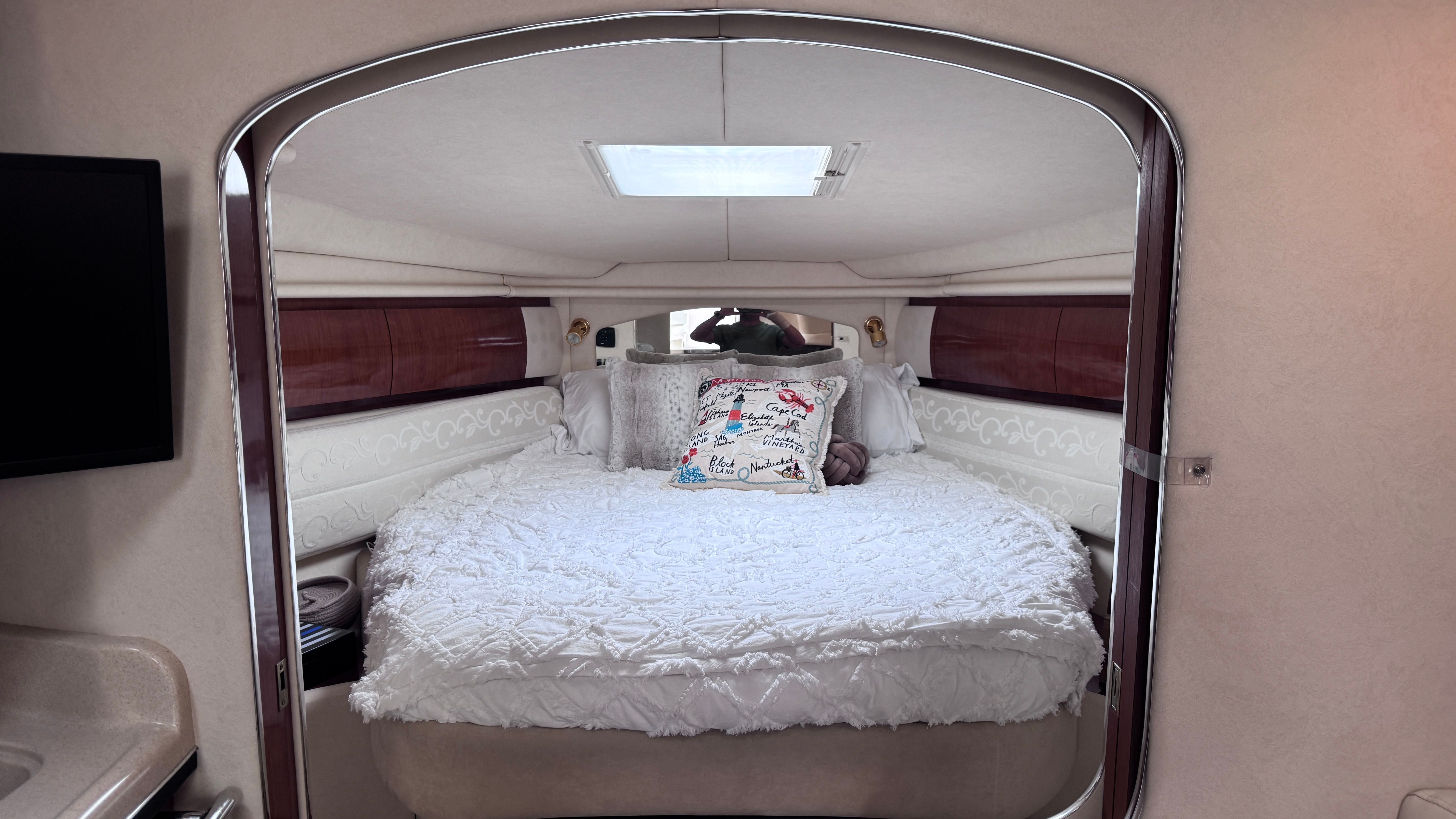 Interior of the 2003 Sea Ray 360 Sundancer with a cozy bed and skylight.