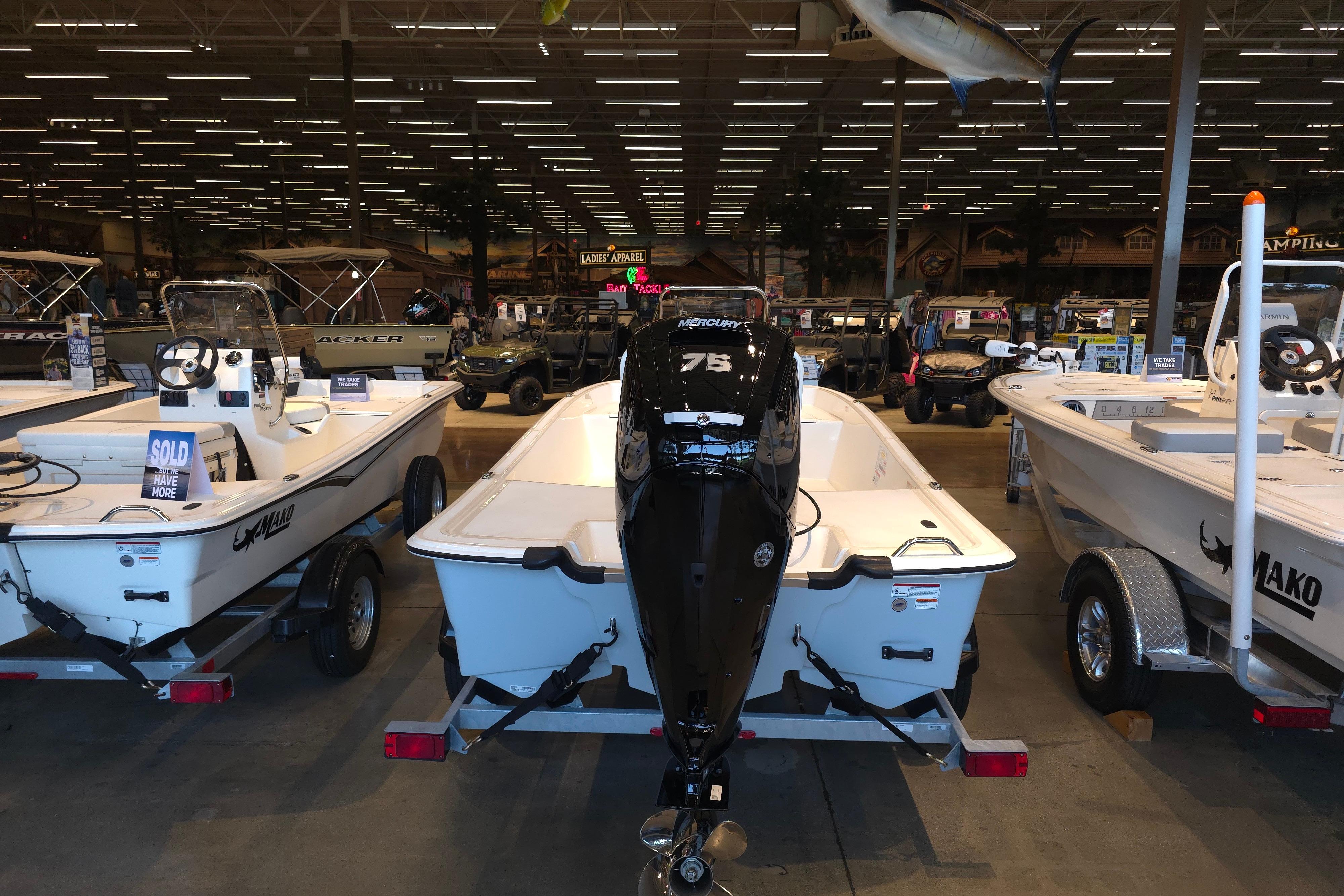 2026 Mako Pro Skiff 17 CC boat displayed indoors with Mercury 75 engine.