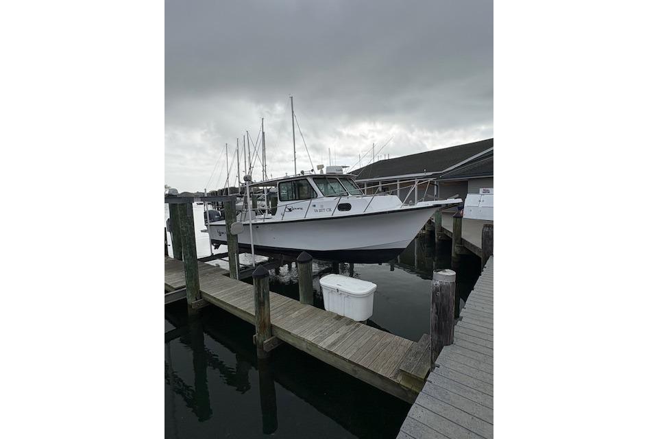 1989 C-Hawk 29 Sport Cabin boat docked at marina under cloudy sky.