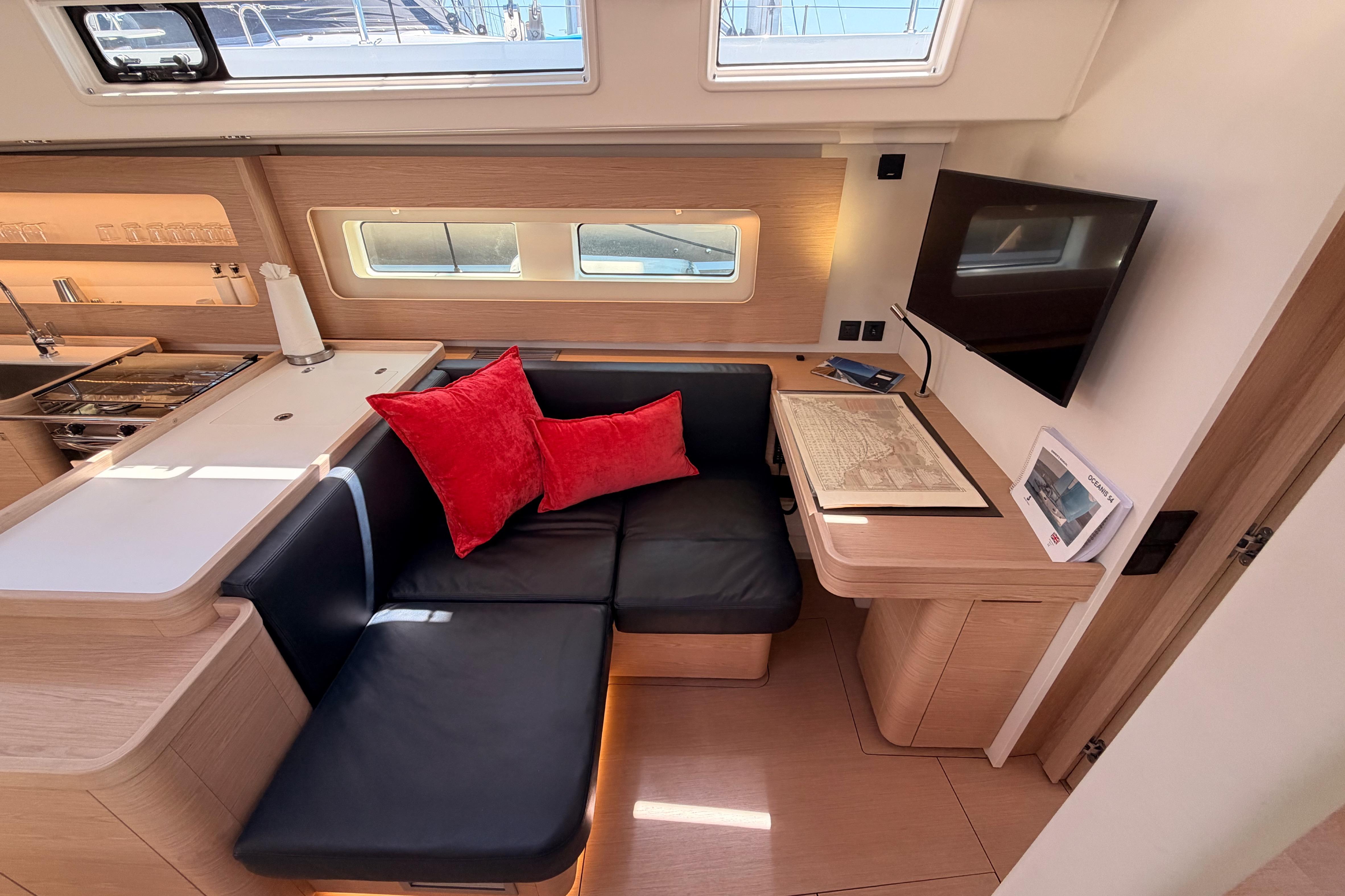 Luxurious interior of 2022 Beneteau Oceanis Yacht 54 with modern seating and navigation table.