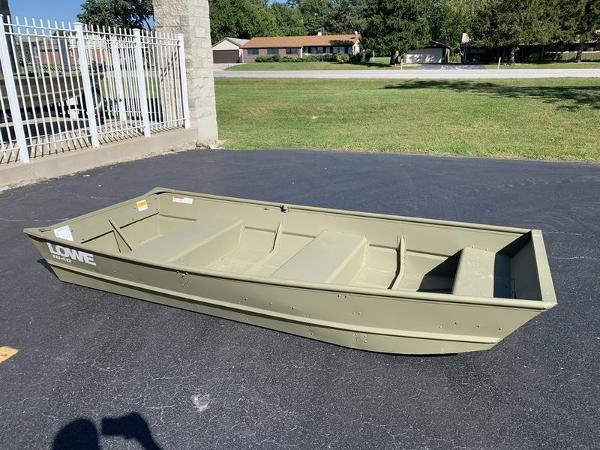 2024 Lowe L1040 Jon boat on pavement, near a fence and grassy area.