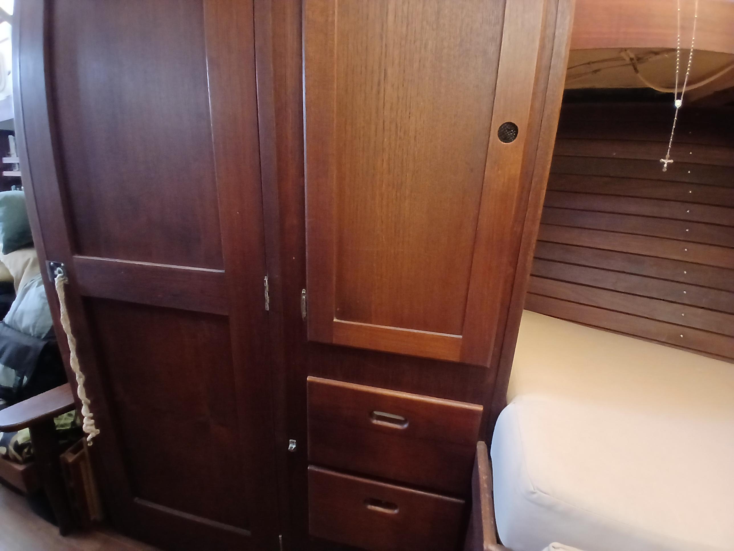 Wooden interior of a 1977 Dickerson 41 sailboat, featuring cabinets and a cozy sleeping area.
