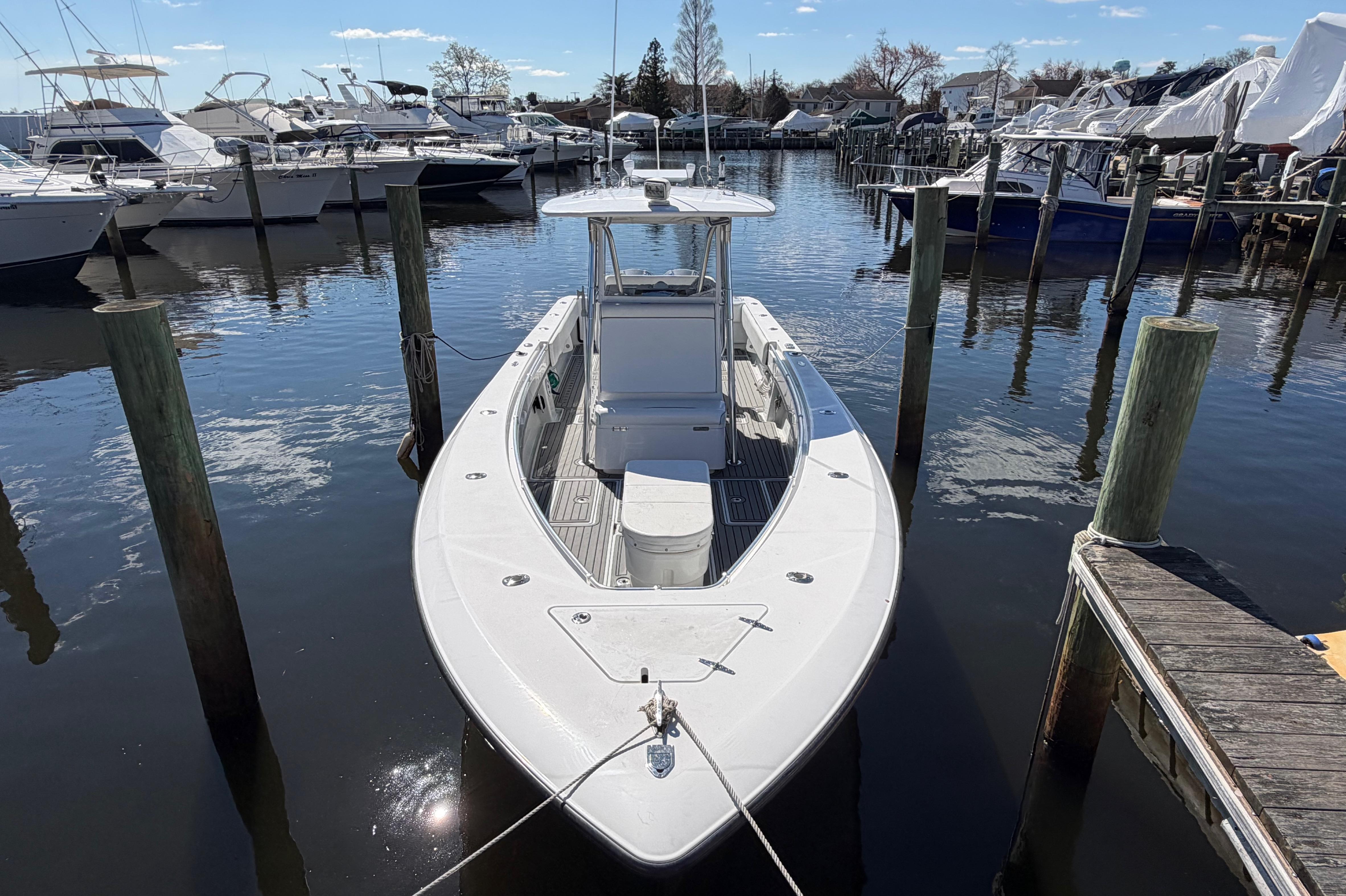 2015 Contender 32 ST boat docked in a marina, surrounded by other vessels.