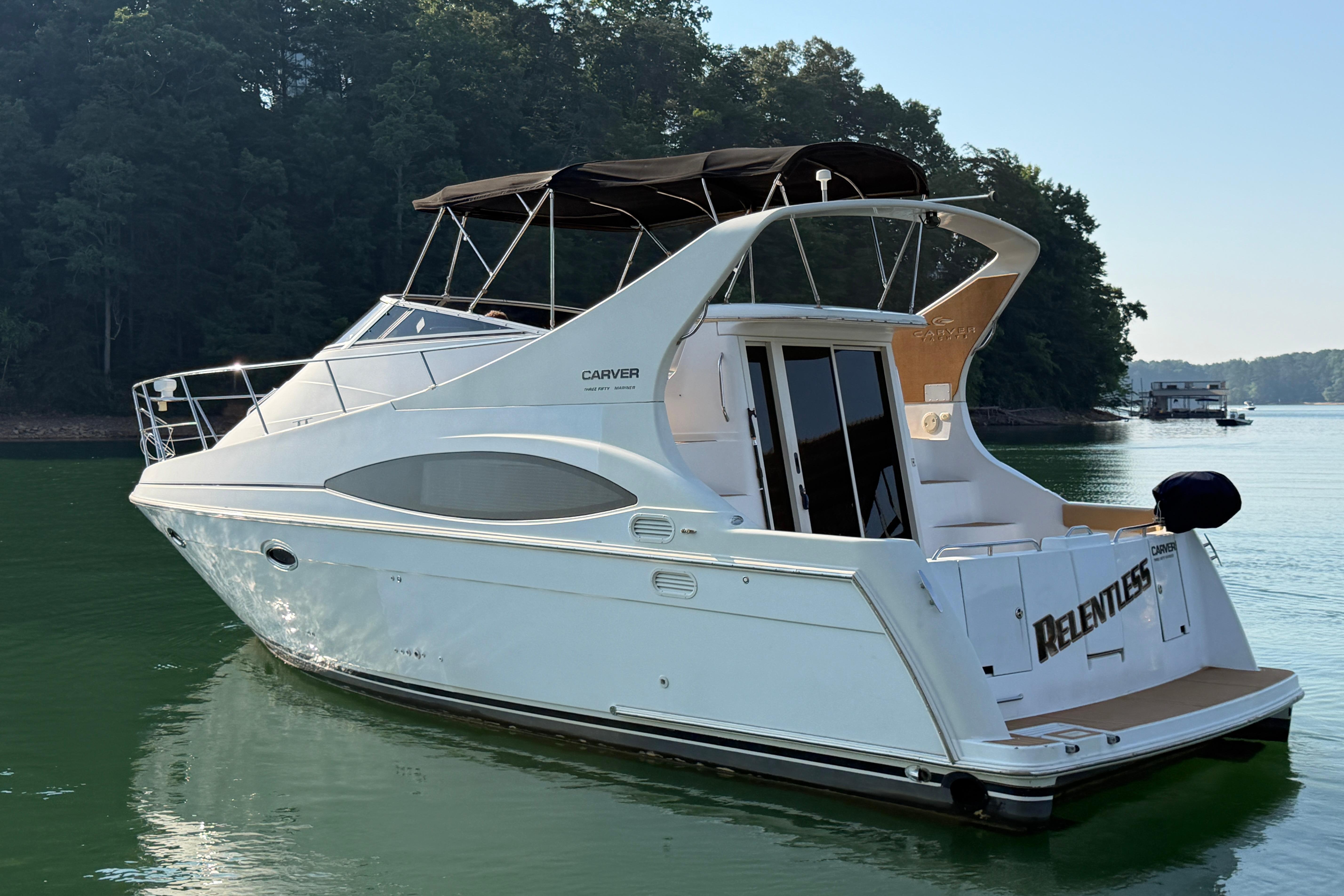 2003 Carver 350 Mariner yacht on calm water, surrounded by trees.