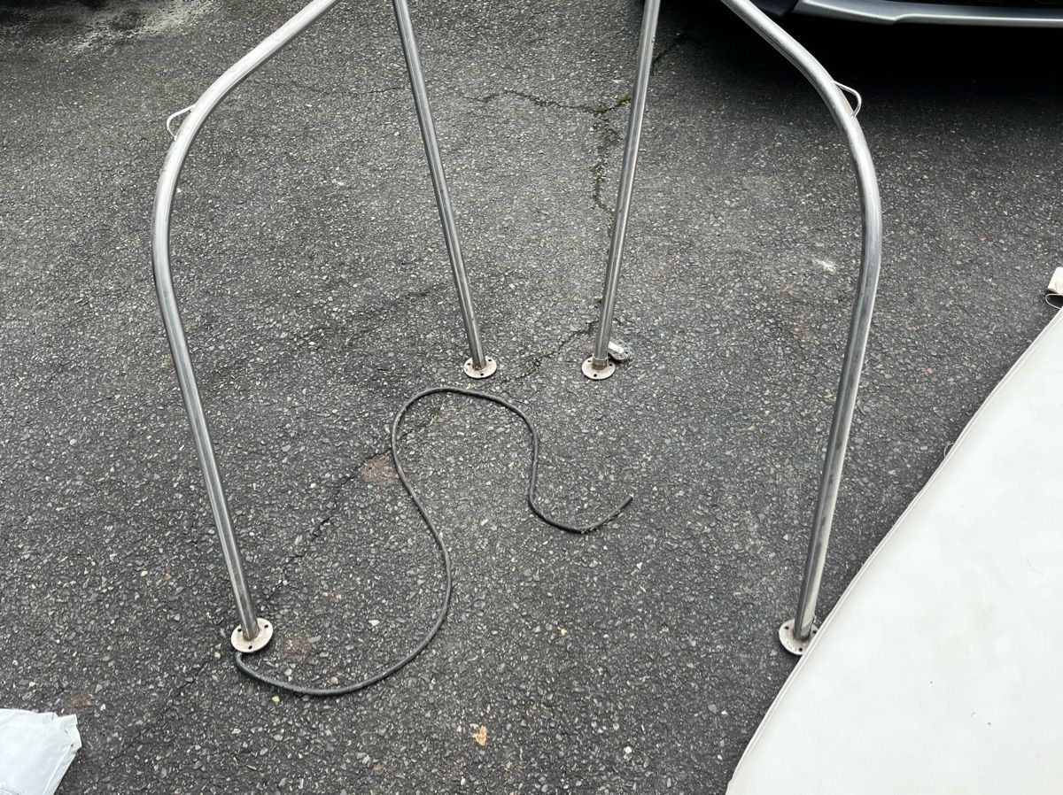 Metal railing on asphalt, possibly part of a boat.