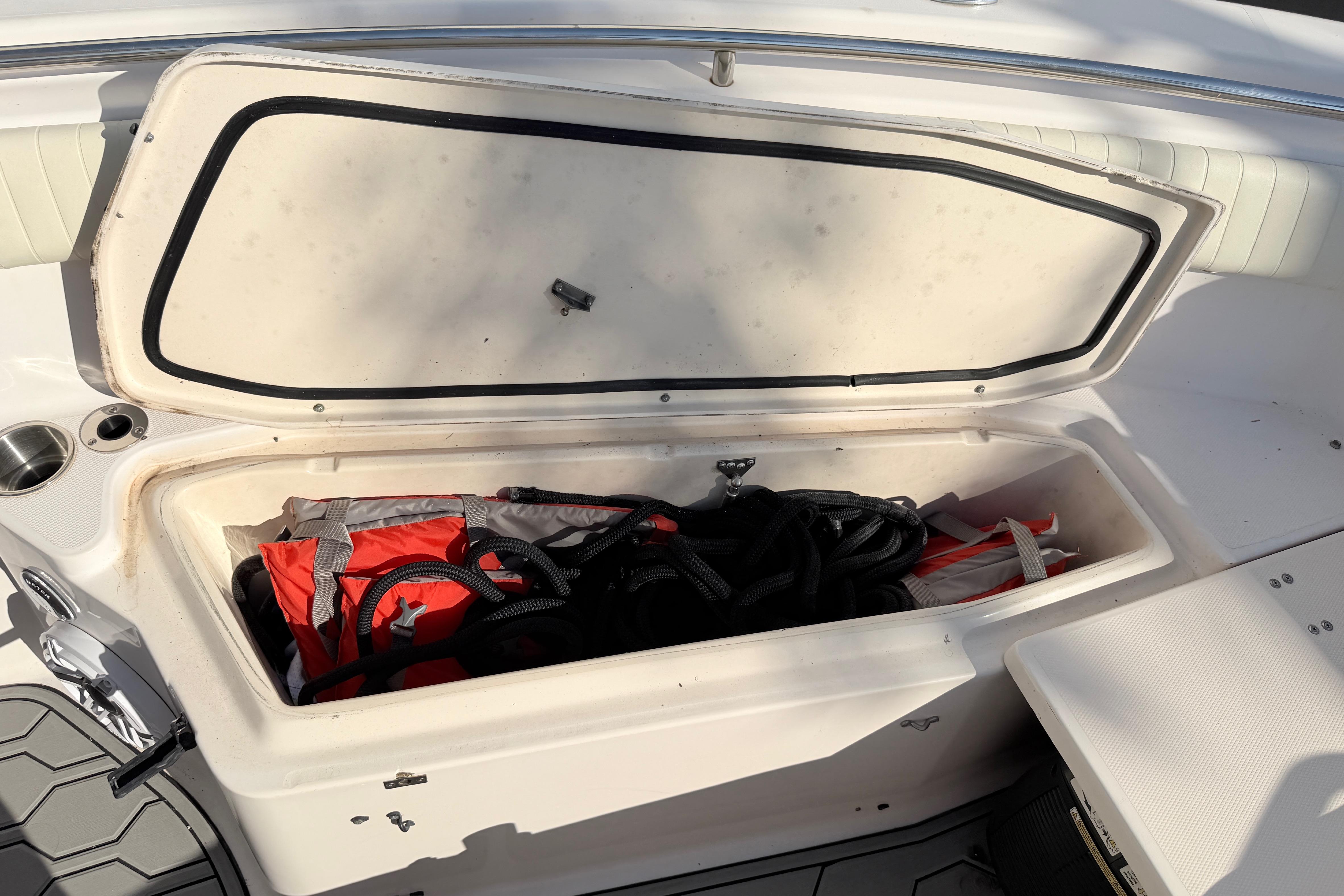 Open storage compartment on 2004 Grady White 273 boat with life jacket and ropes.