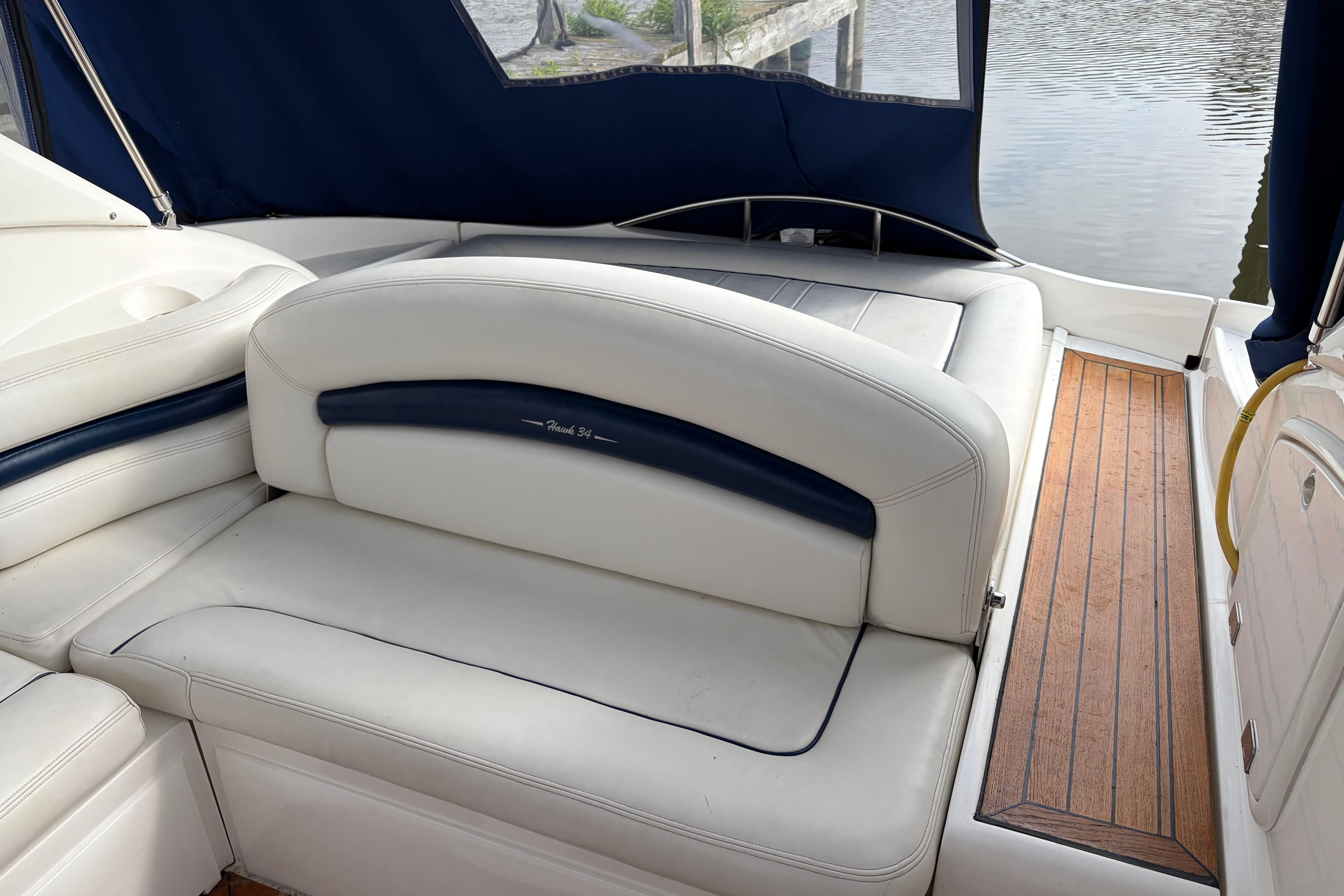 Sunseeker Superhawk 34 yacht interior, featuring white leather seating and wooden flooring, 2000 model.