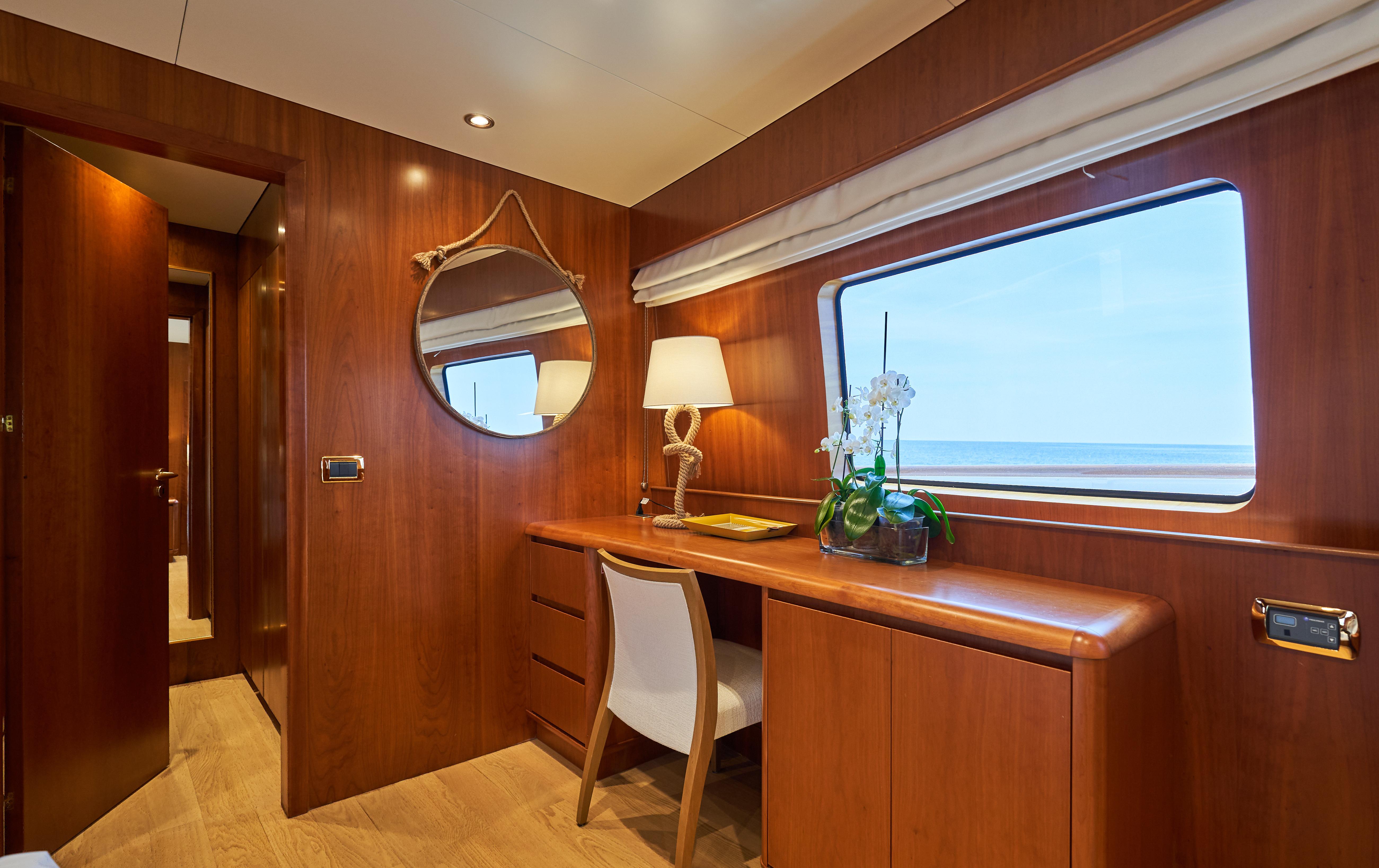 Luxurious interior of 2009 Castagnola Navetta 33 yacht with wooden desk and ocean view.