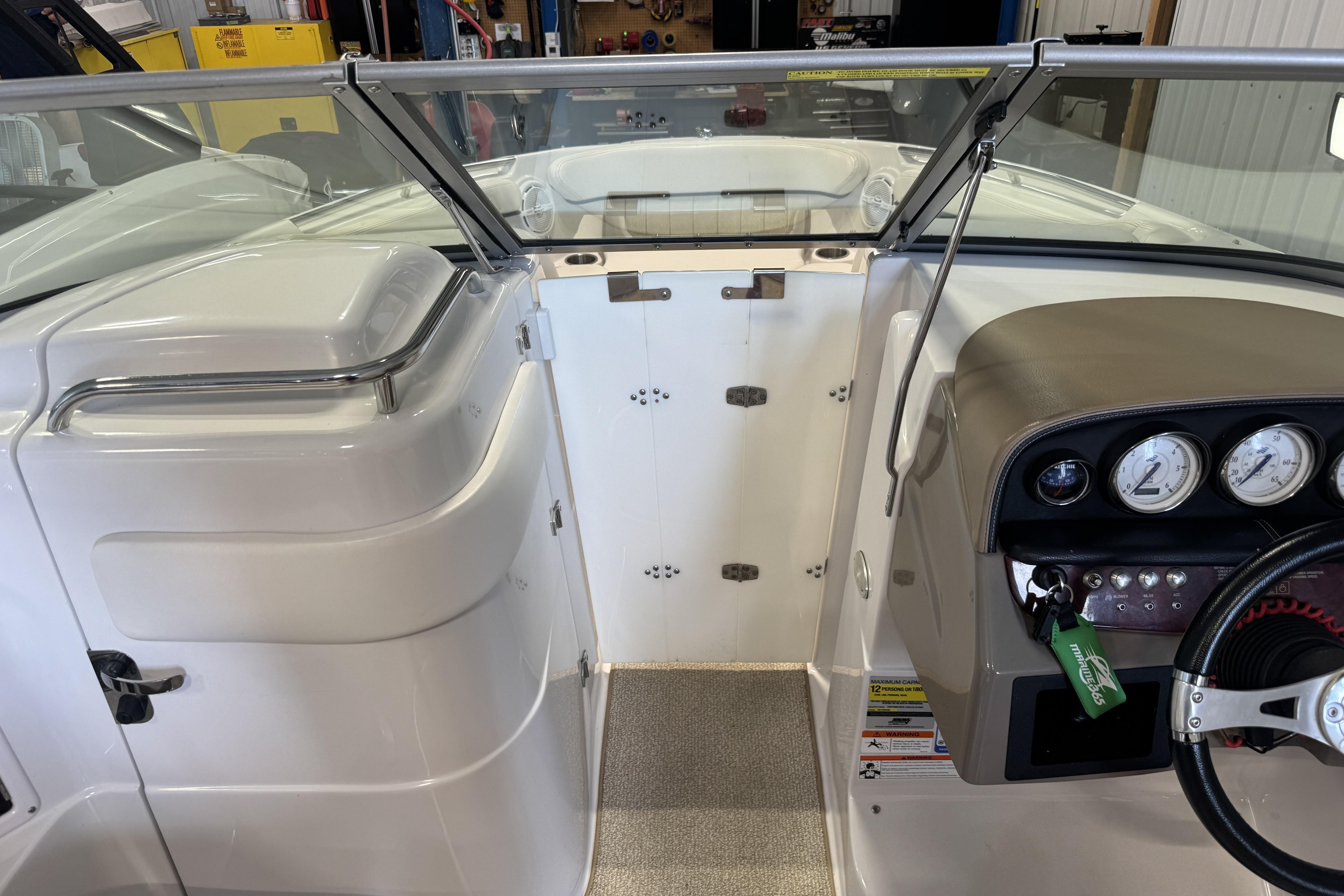 Interior view of a 2008 Four Winns H240 boat cockpit with steering wheel and gauges.