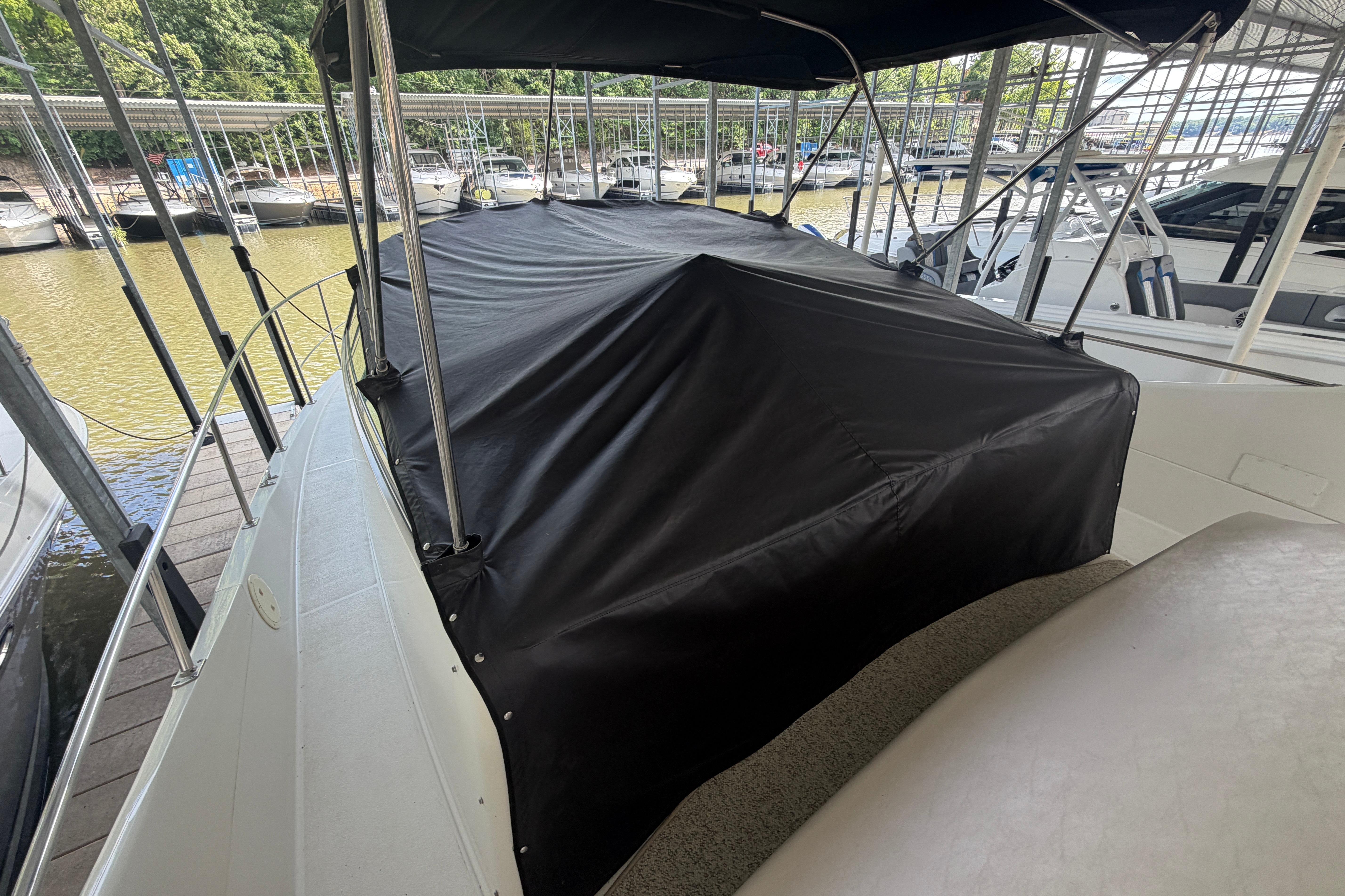 2000 Carver 350 Mariner yacht with black cover docked at marina.