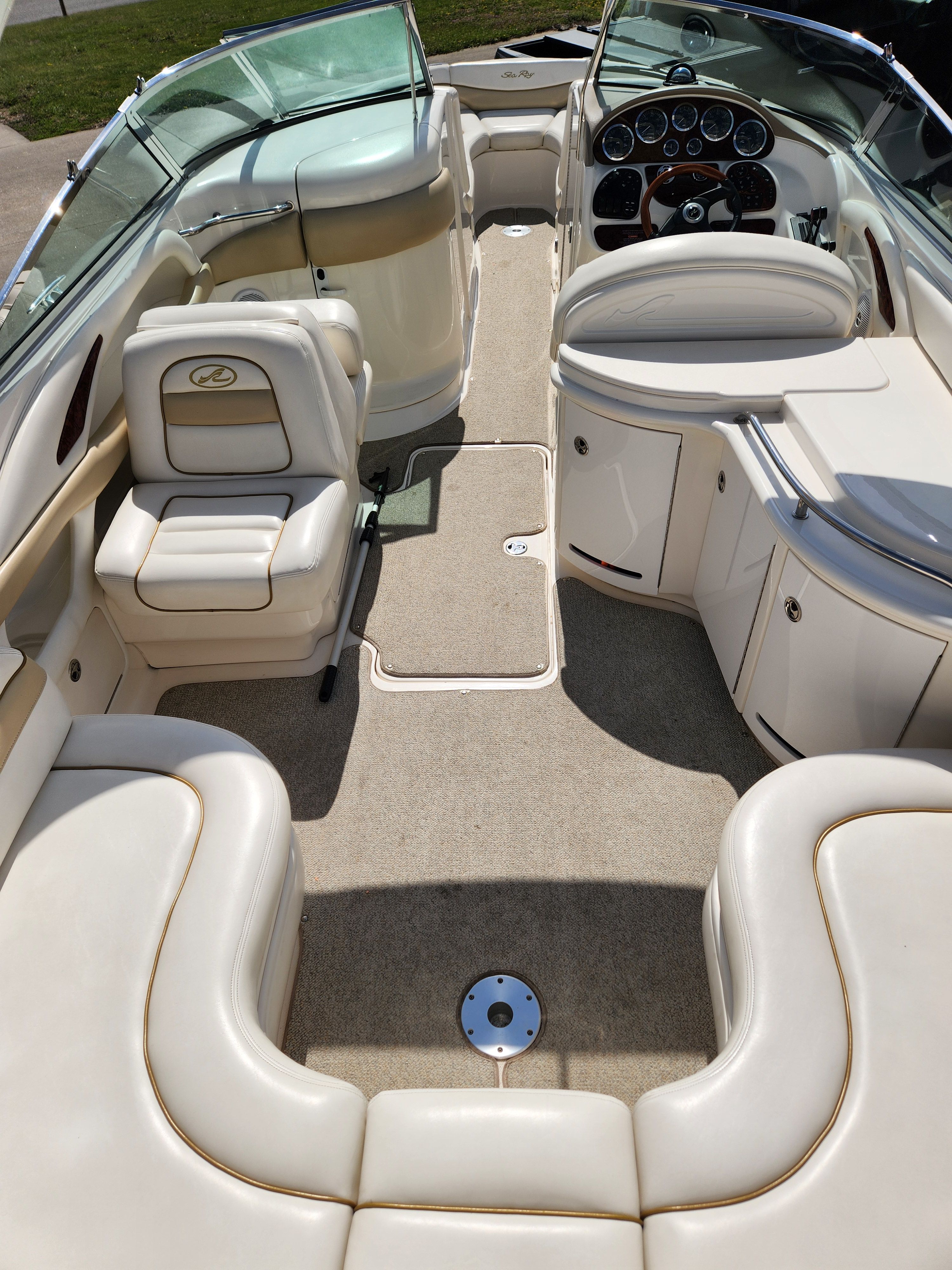 Interior of a Sea Ray 290 BR boat with beige seating and dashboard.