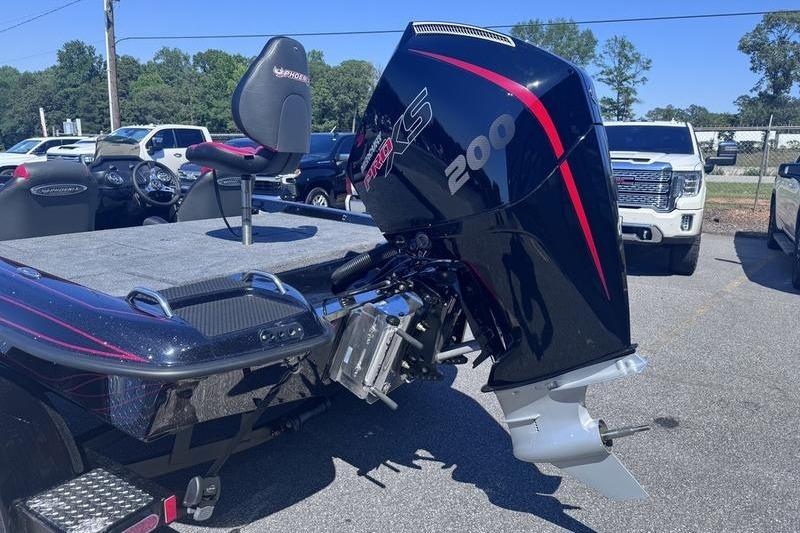 2026 Phoenix 819 ZXL boat with powerful 200 HP engine, parked outdoors.