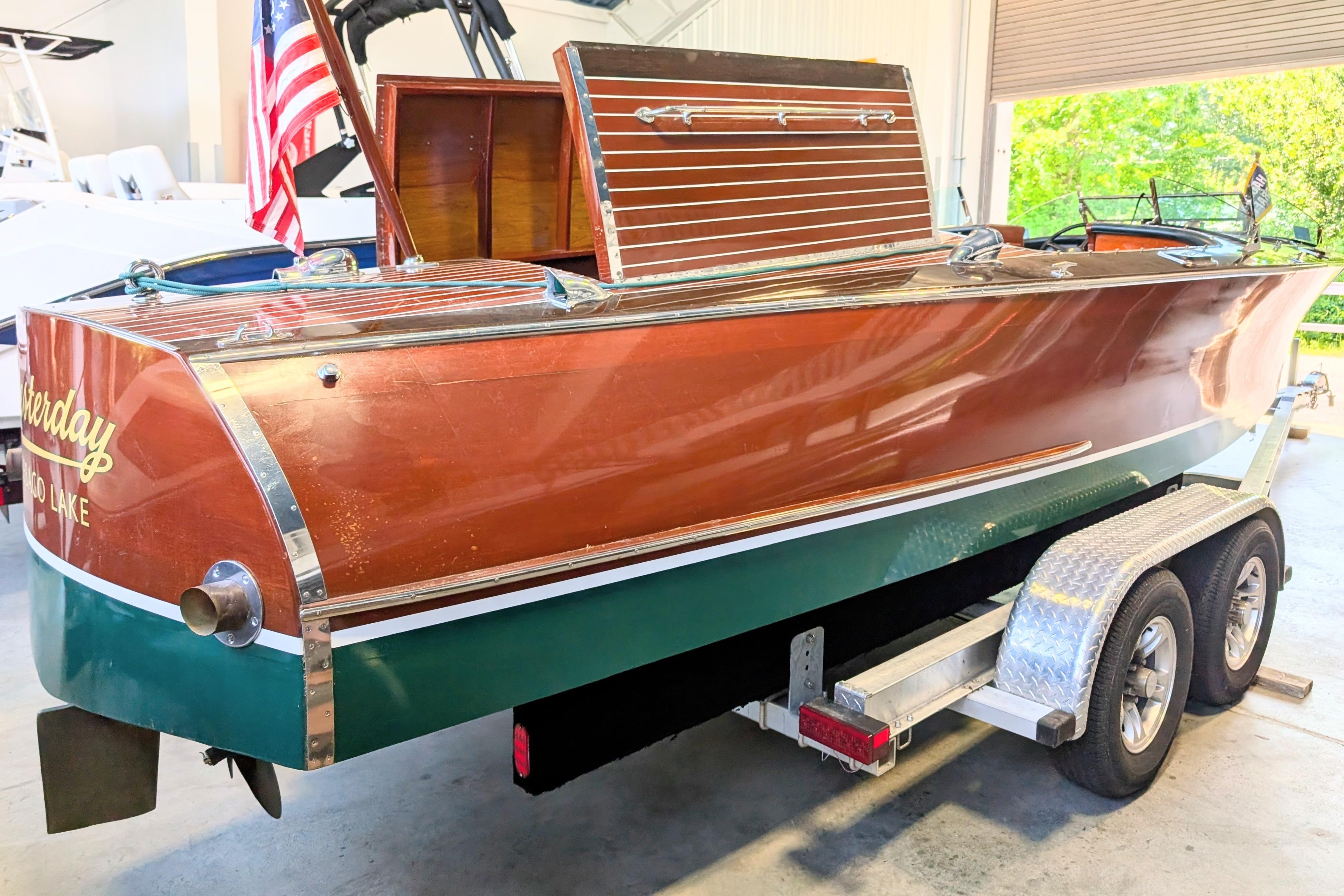 2001 Hacker-Craft 24 Dual Console boat on trailer, featuring classic wooden design and American flag.