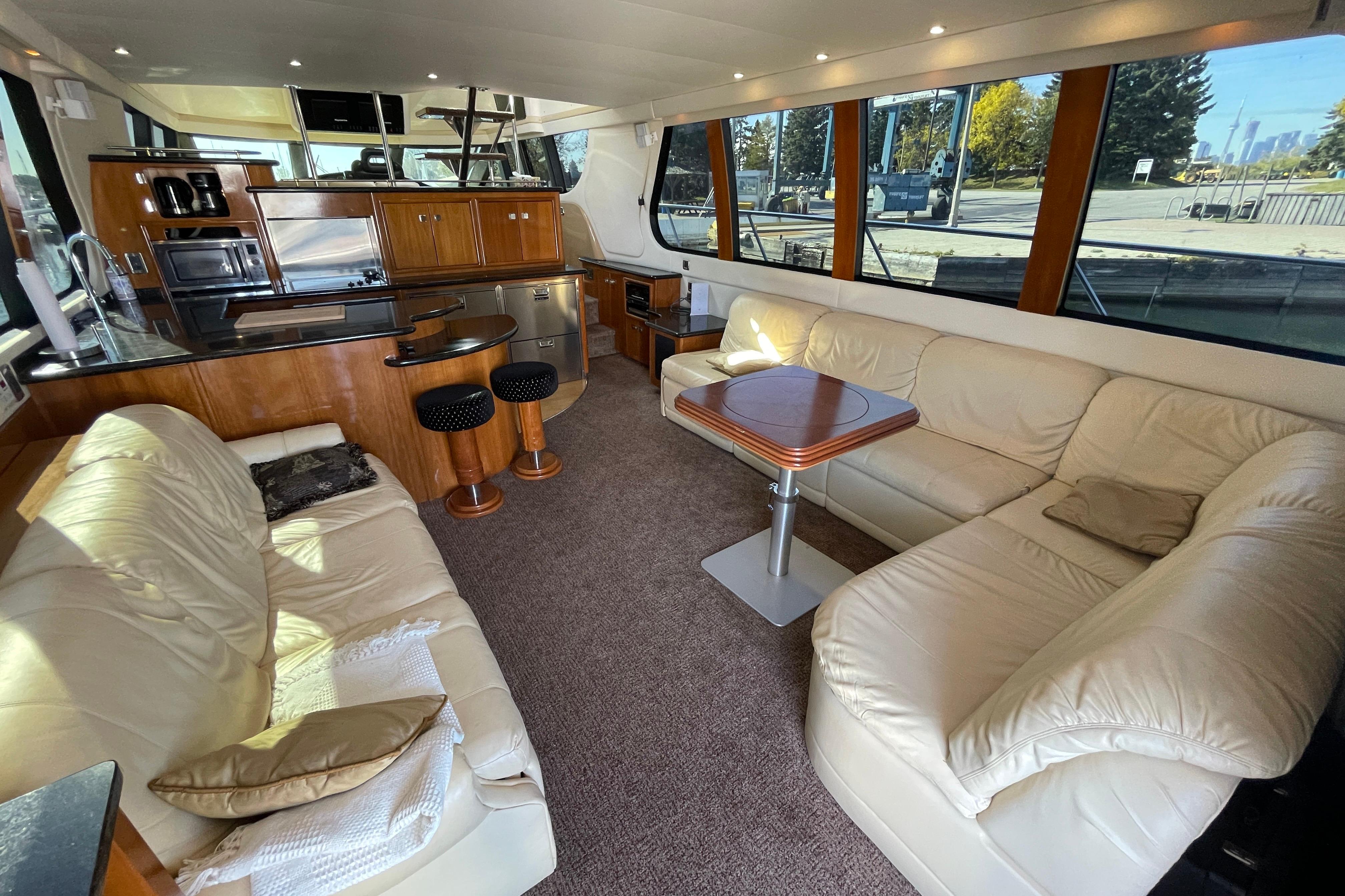 Luxurious interior of 2002 Carver 570 Voyager Pilothouse with leather seating and modern kitchen.