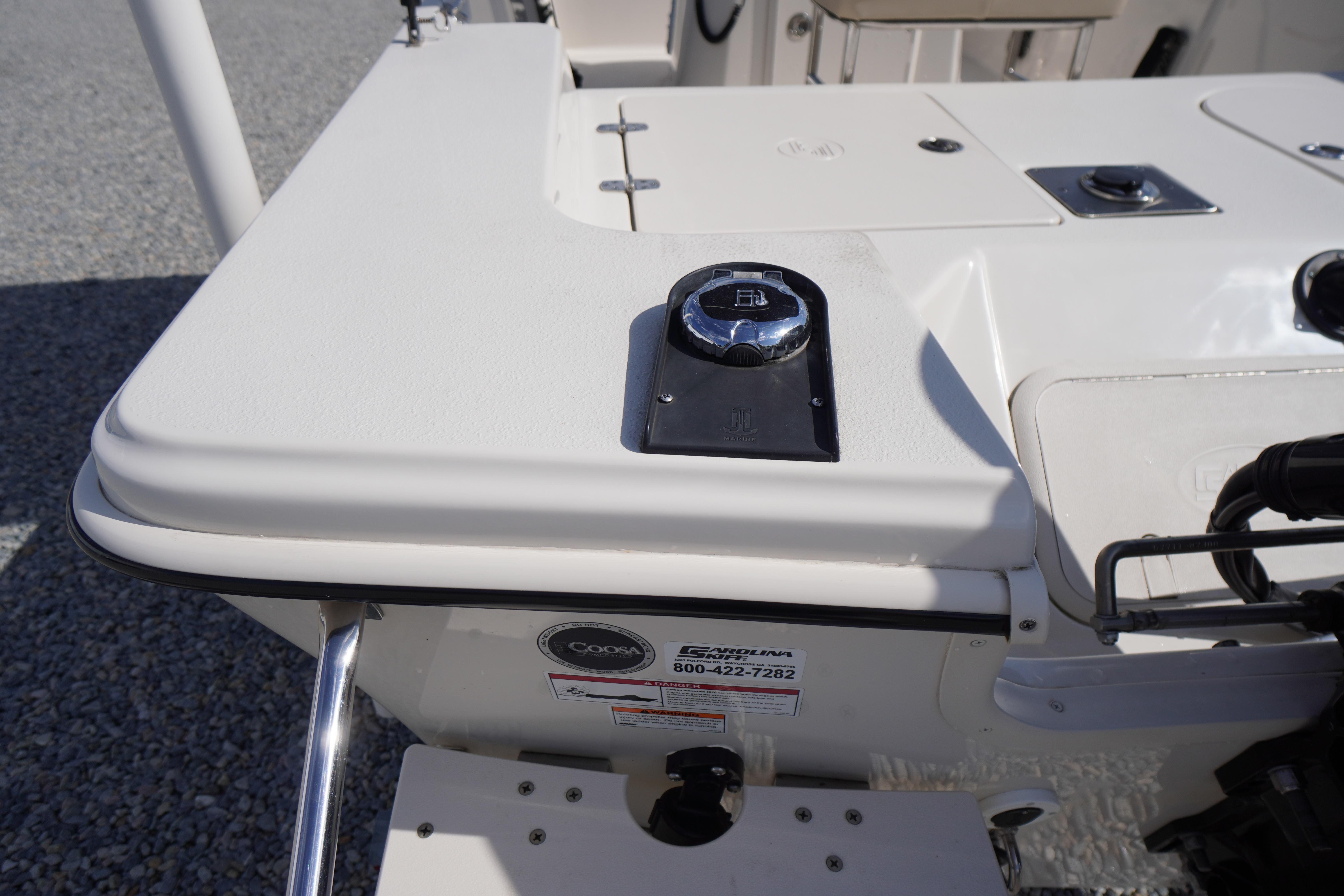 2024 Carolina Skiff 182 boat deck with control panel and storage compartments.