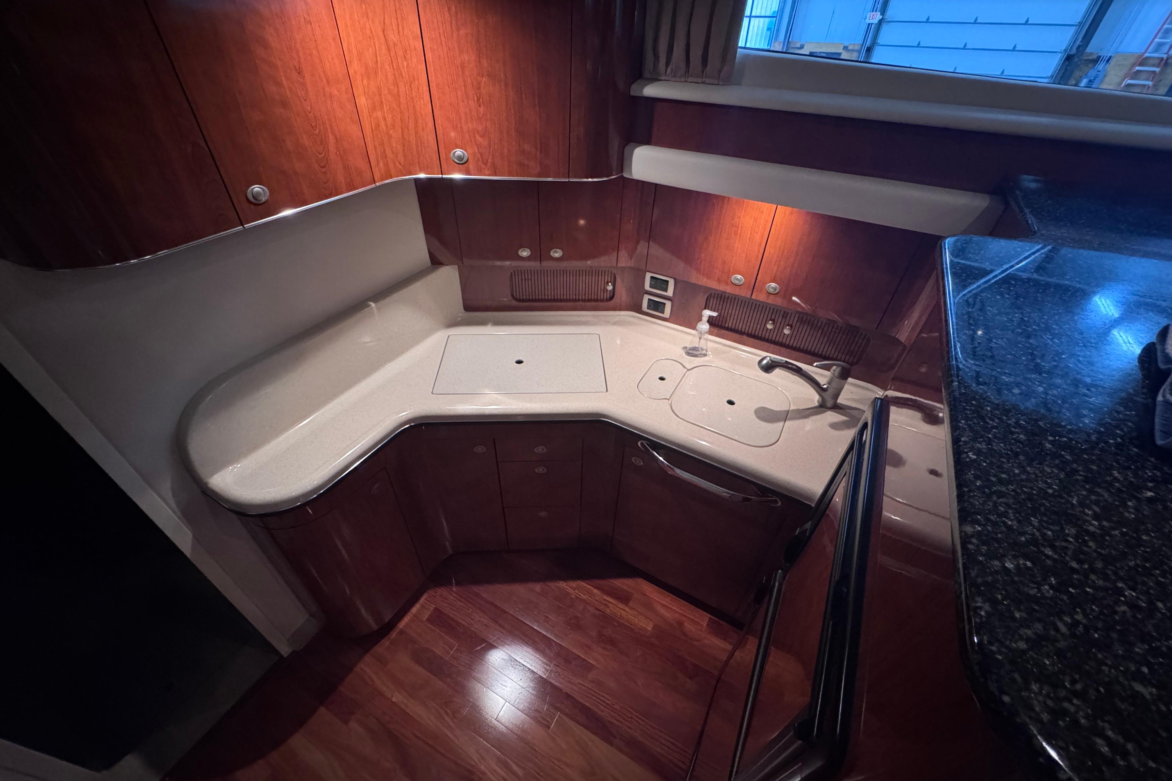 Luxurious 2004 Sea Ray 390 Motor Yacht kitchen with sleek wood cabinetry and modern fixtures.