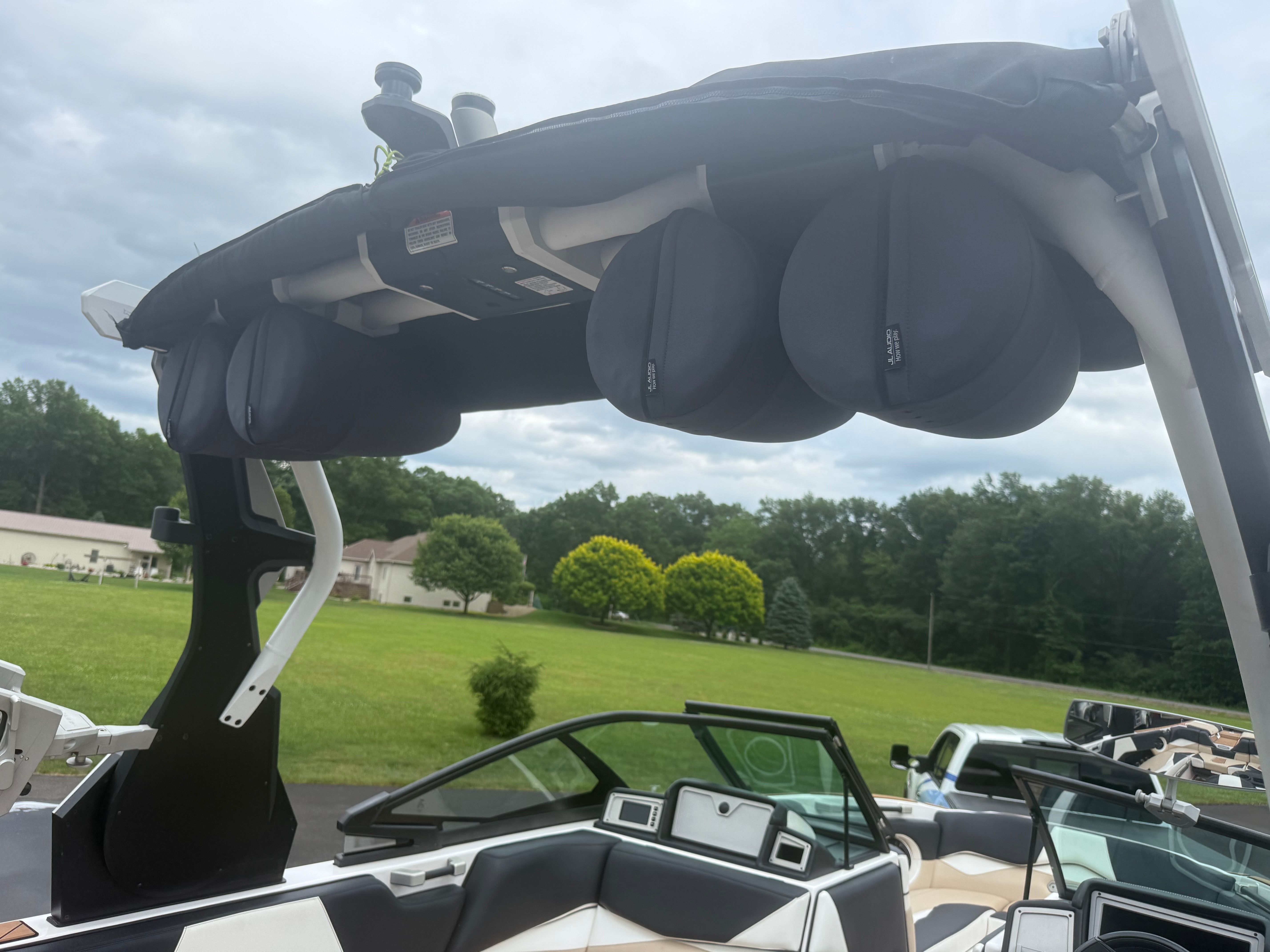 The image shows the cockpit of a 2019 Supra SL boat with a black bimini top.