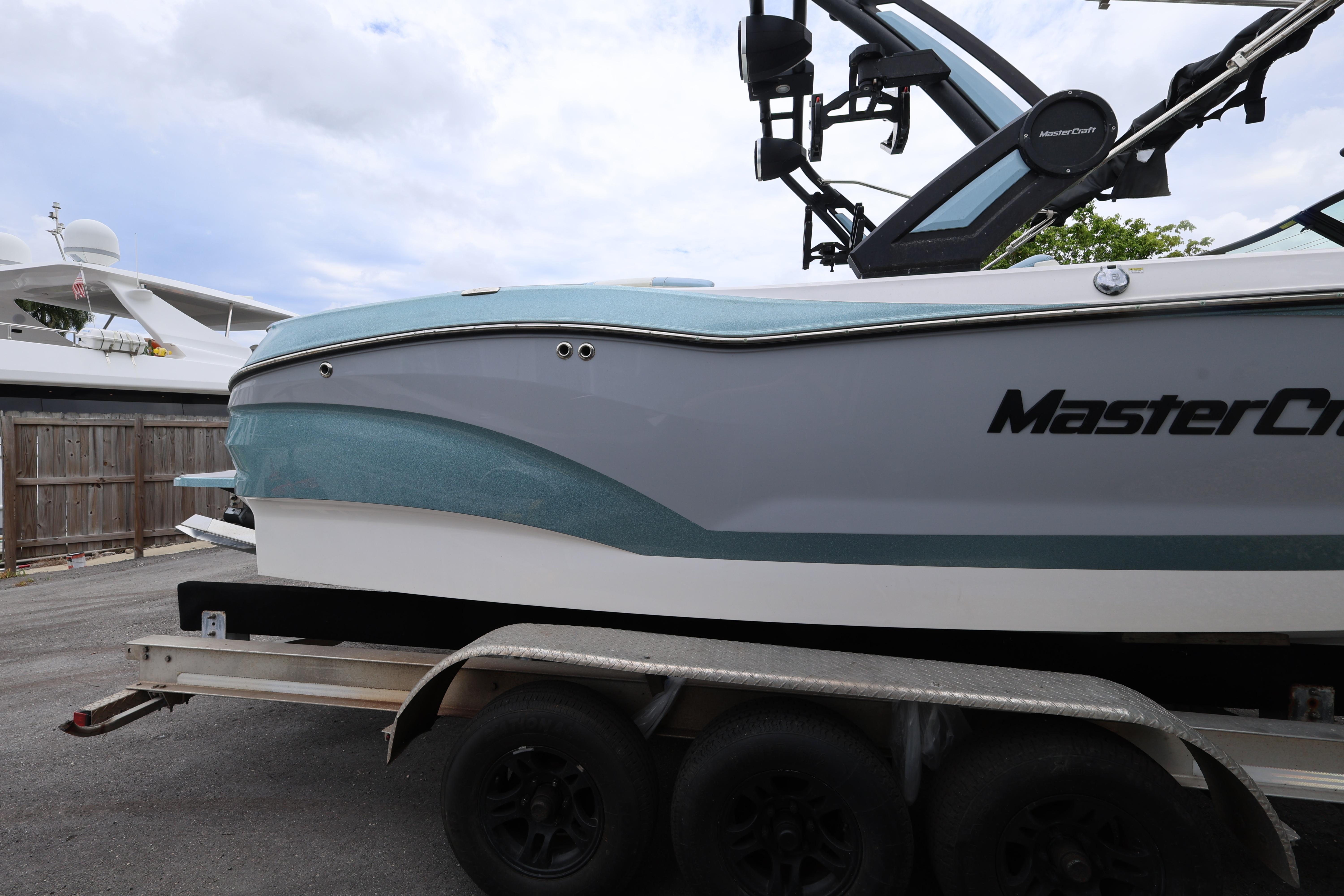 2023 MasterCraft X24 boat on trailer, side view with sleek design and modern features.
