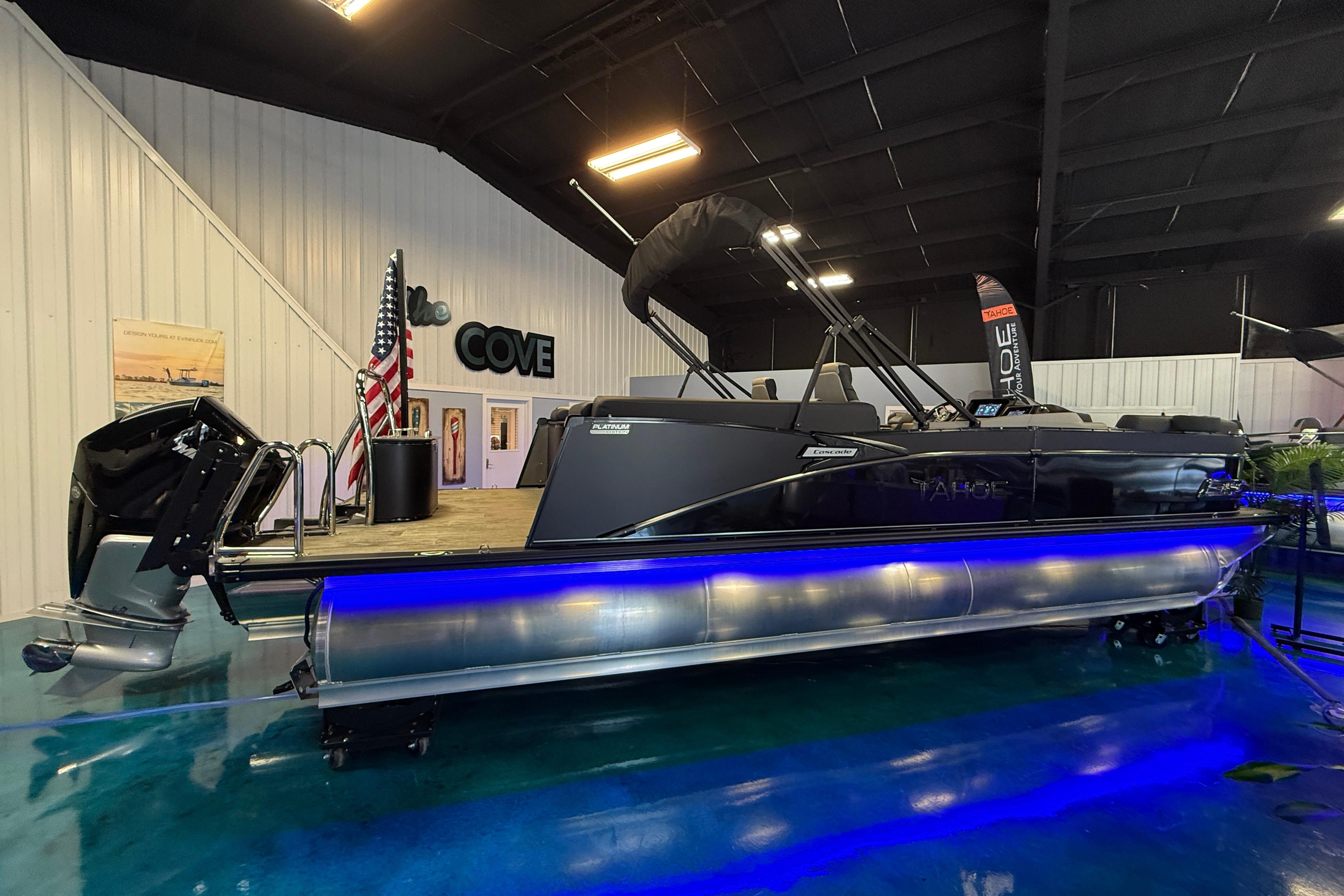 2026 Tahoe Pontoon Cascade Cruise Rear Bench with blue LED lights in showroom.