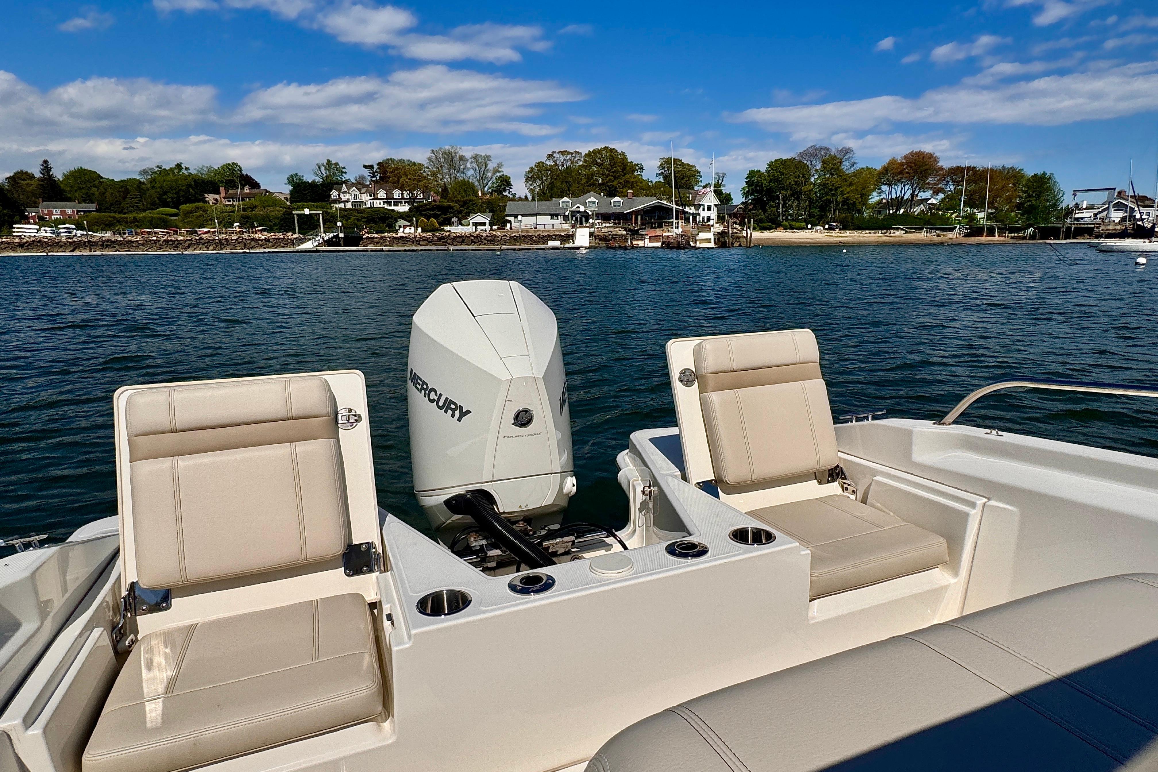 2022 Boston Whaler 220 Dauntless boat with Mercury engine on calm water.