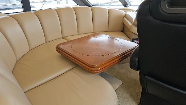 Luxurious seating area in 2000 Carver 450 Voyager Pilothouse with wooden table.