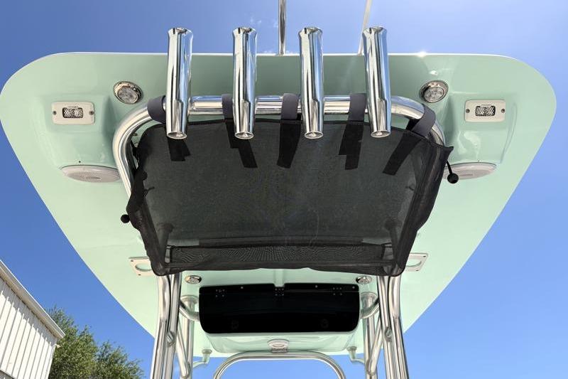2024 Key West 203 FS boat T-top with rod holders and speakers under clear sky.