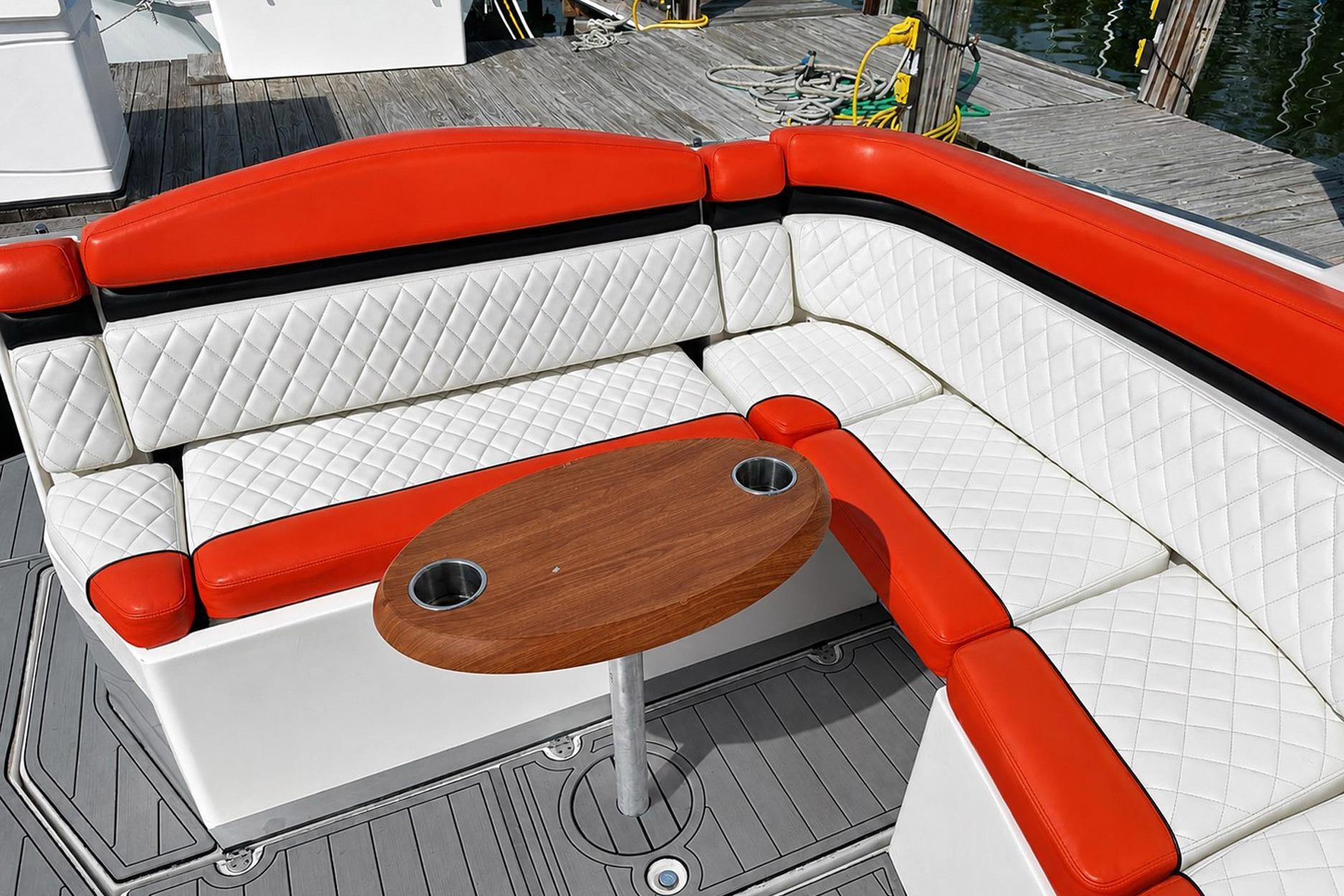 Luxurious seating on 2012 Rinker 310 Express Cruiser LE with red and white upholstery.
