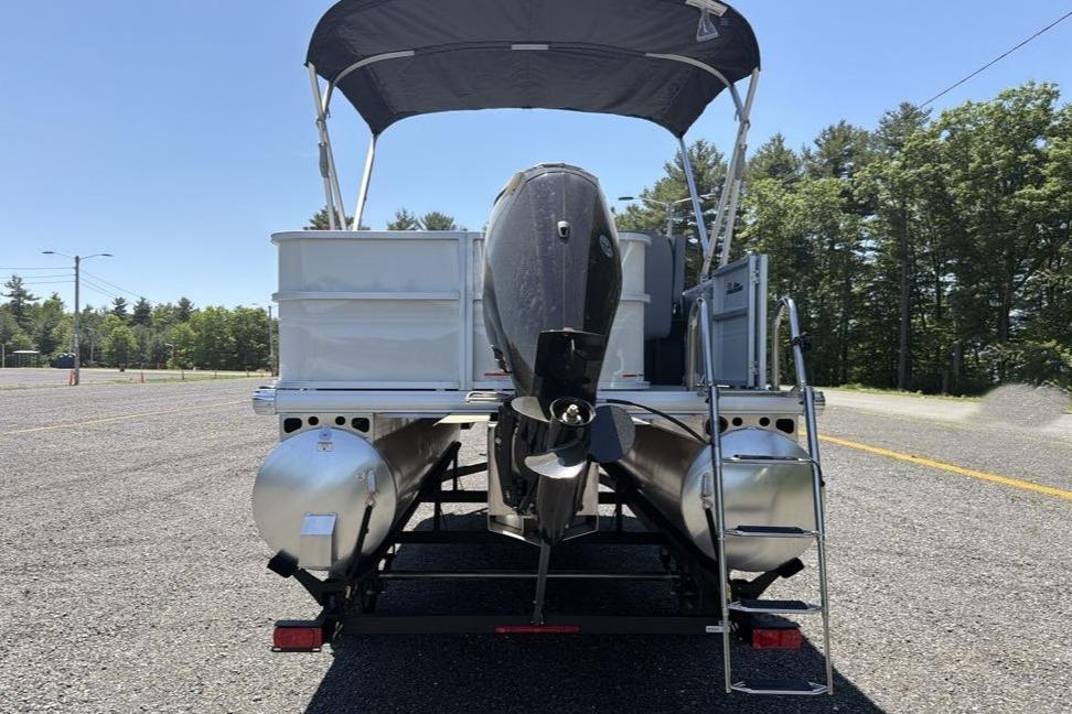 2026 Sun Tracker Party Barge 18 DLX pontoon boat with canopy and outboard motor.