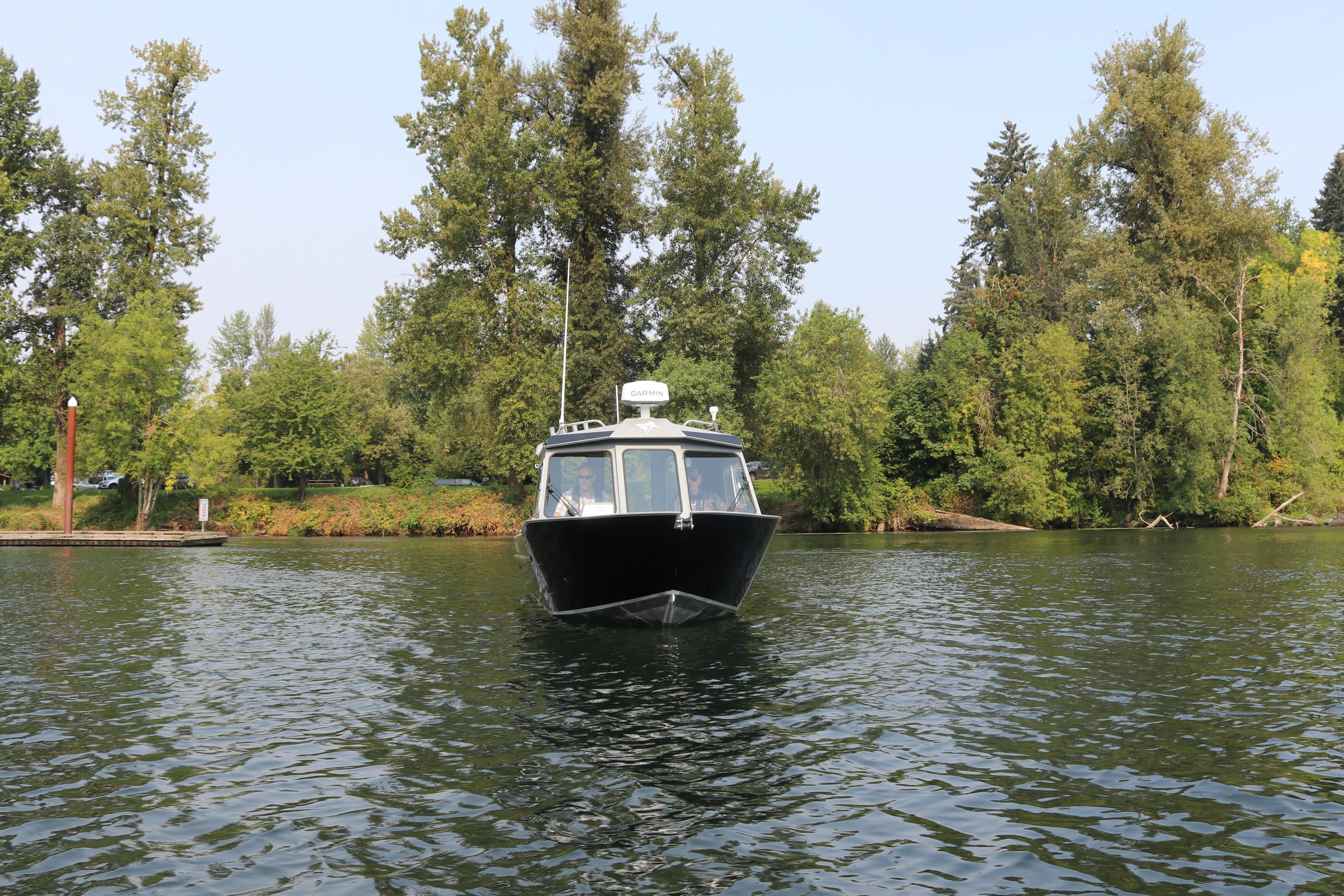KingFisher 2425 Escape HT 2026 on a calm river with trees.