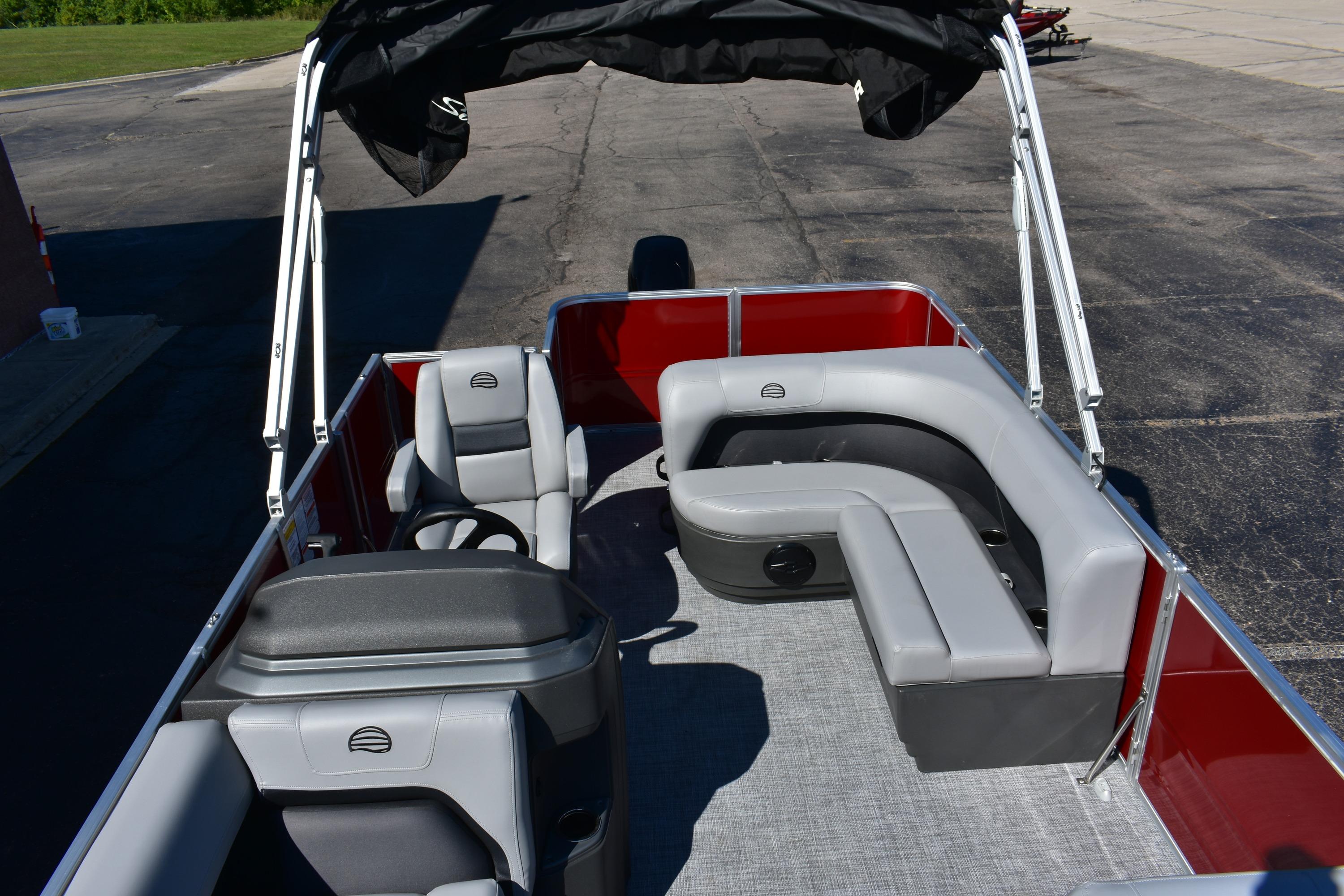 2026 Sun Tracker Party Barge 18 DLX interior with gray seating and canopy.