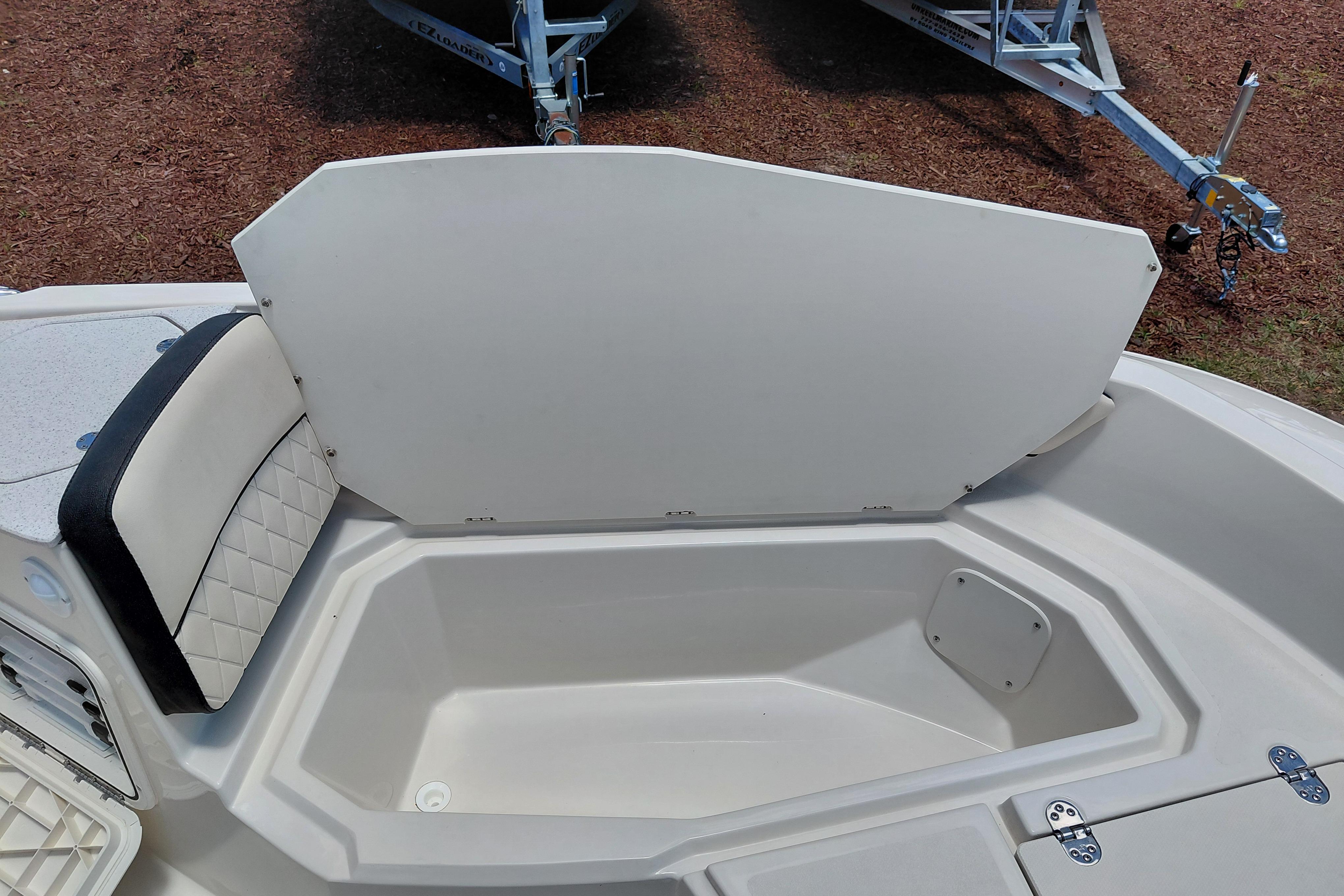 2023 Stingray 206 CC boat storage compartment with open lid and cushioned seating.