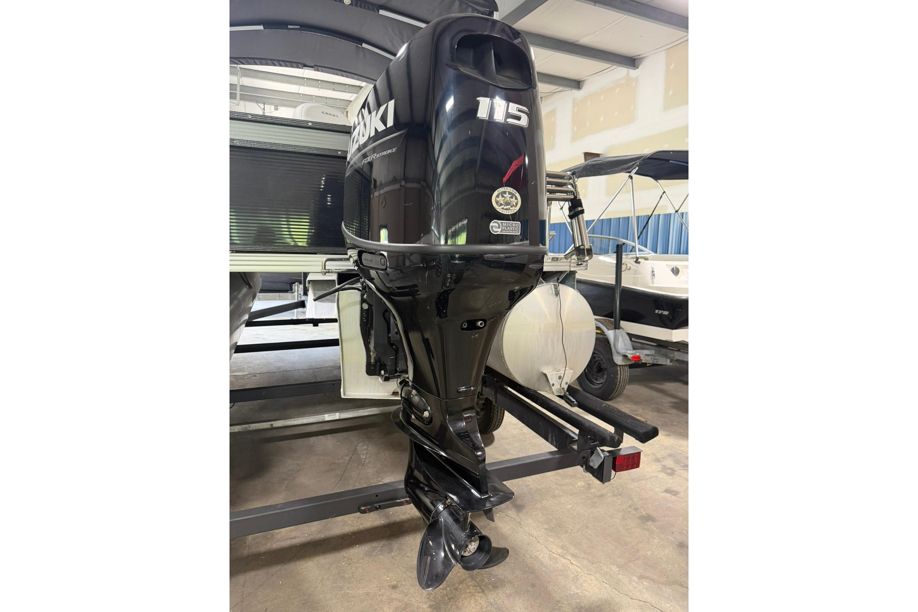 2023 Crest Classic LX 200 with Suzuki 115 outboard motor in a garage setting.