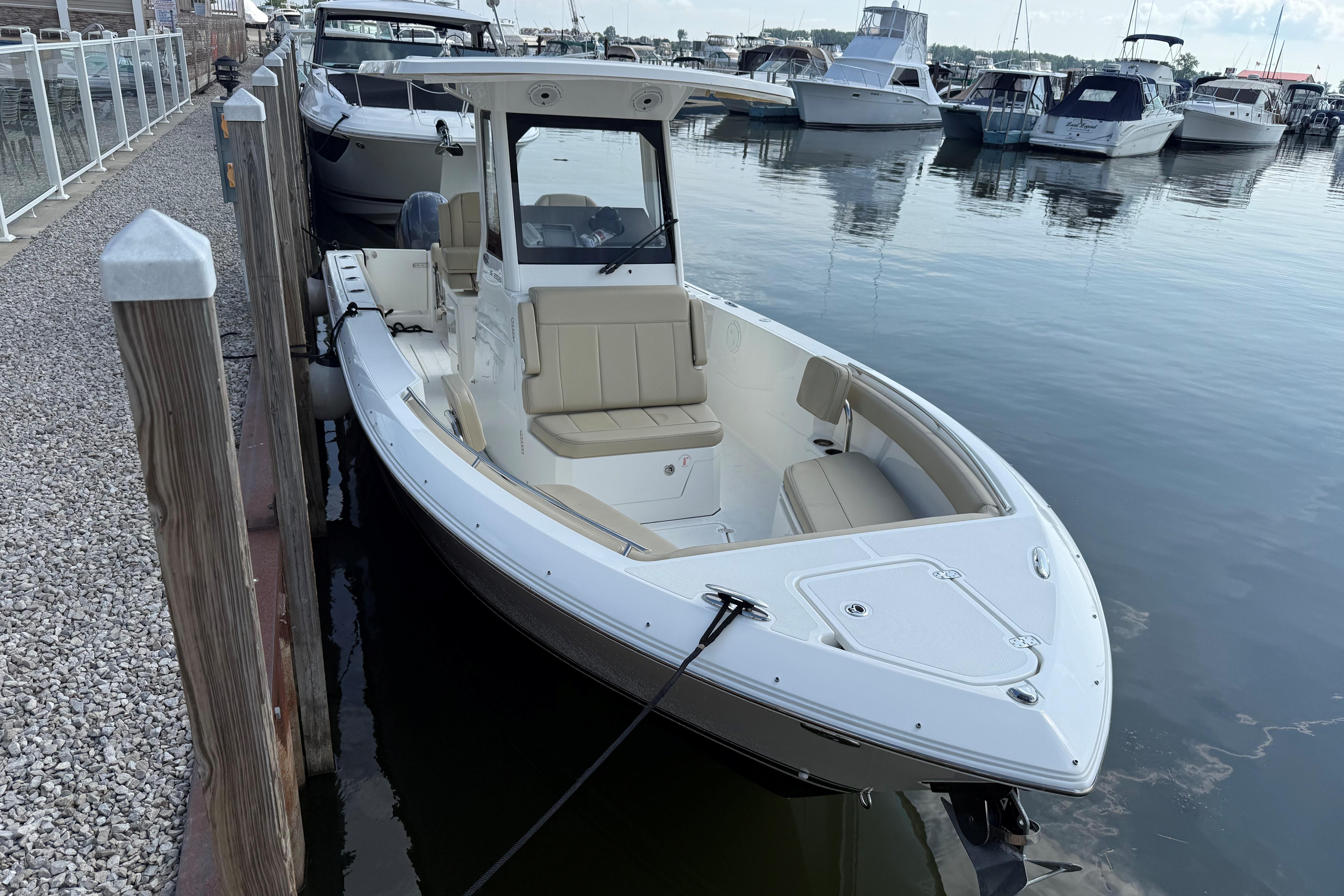 2021 Pursuit S 268 Sport boat docked at a marina with other vessels.