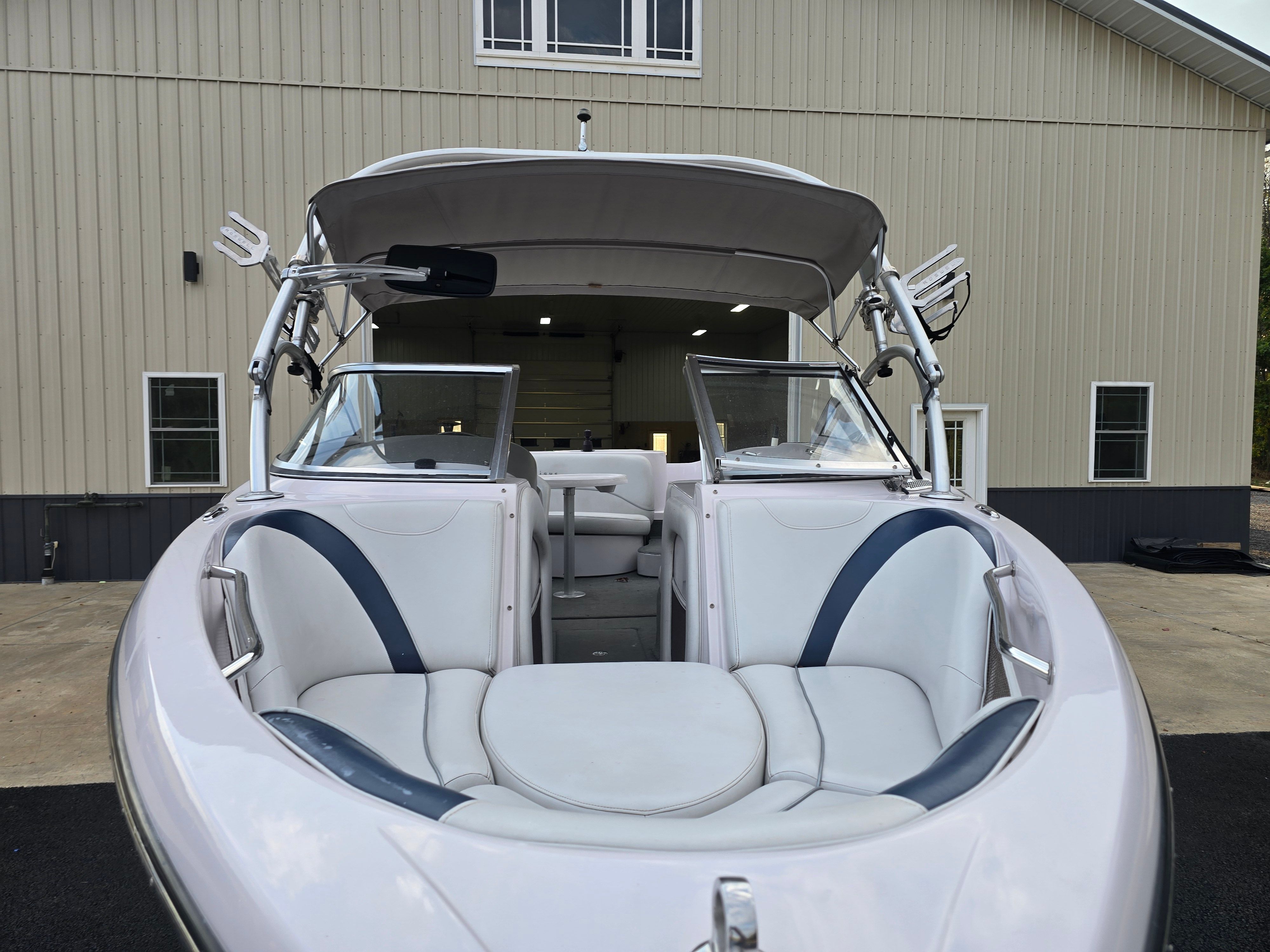 2006 Correct Craft 228 boat in front of warehouse.