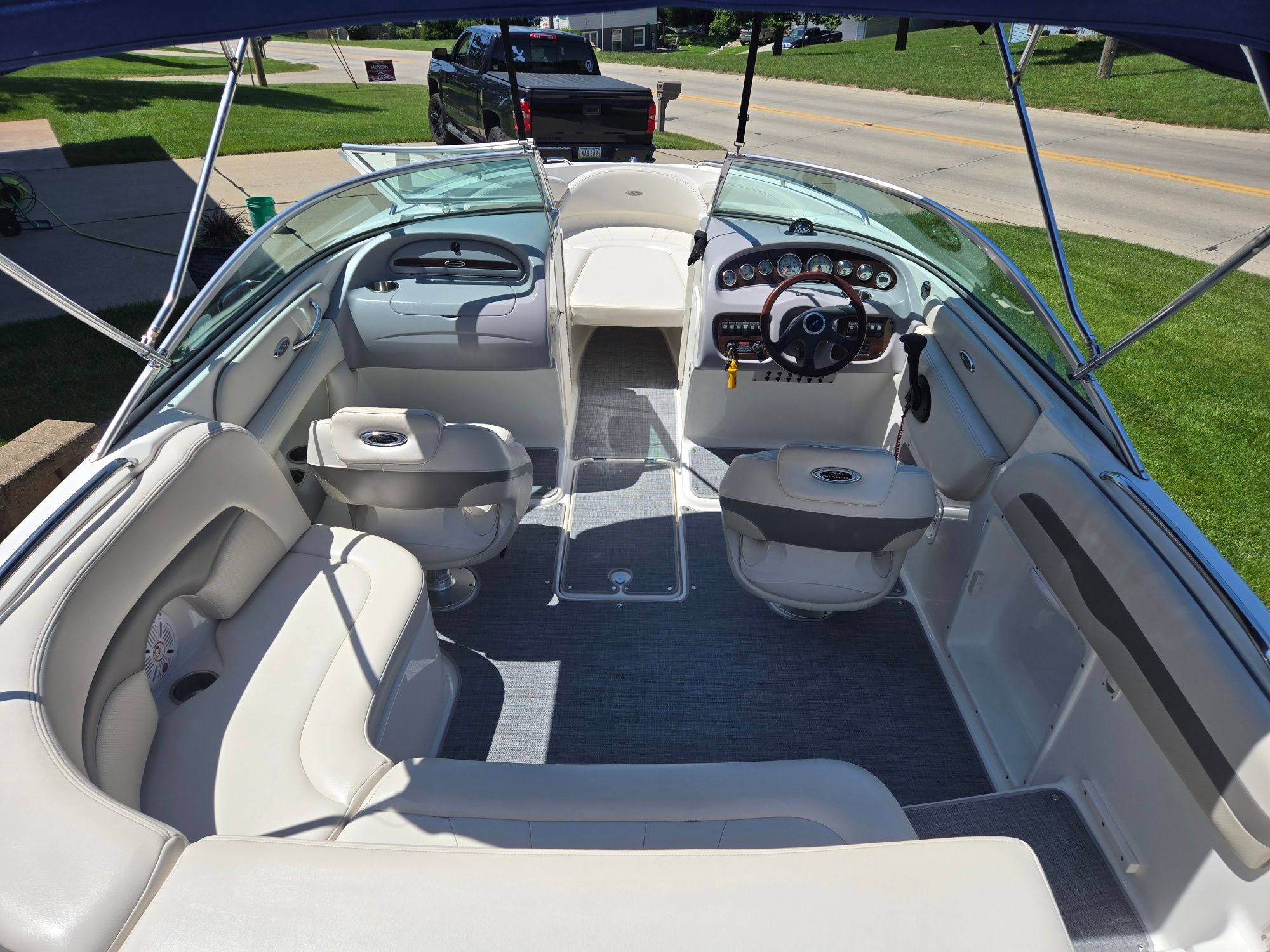 Interior view of a Chaparral 220 SSi boat with beige seating and a helm station.