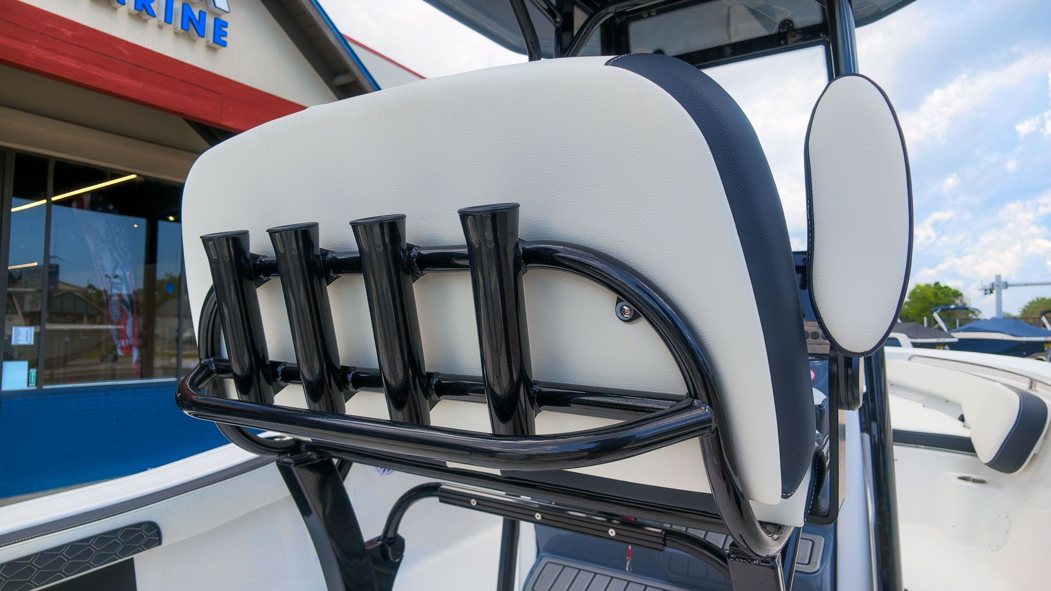 Rear view of a boat seat with integrated rod holders, surrounded by a modern boat deck.