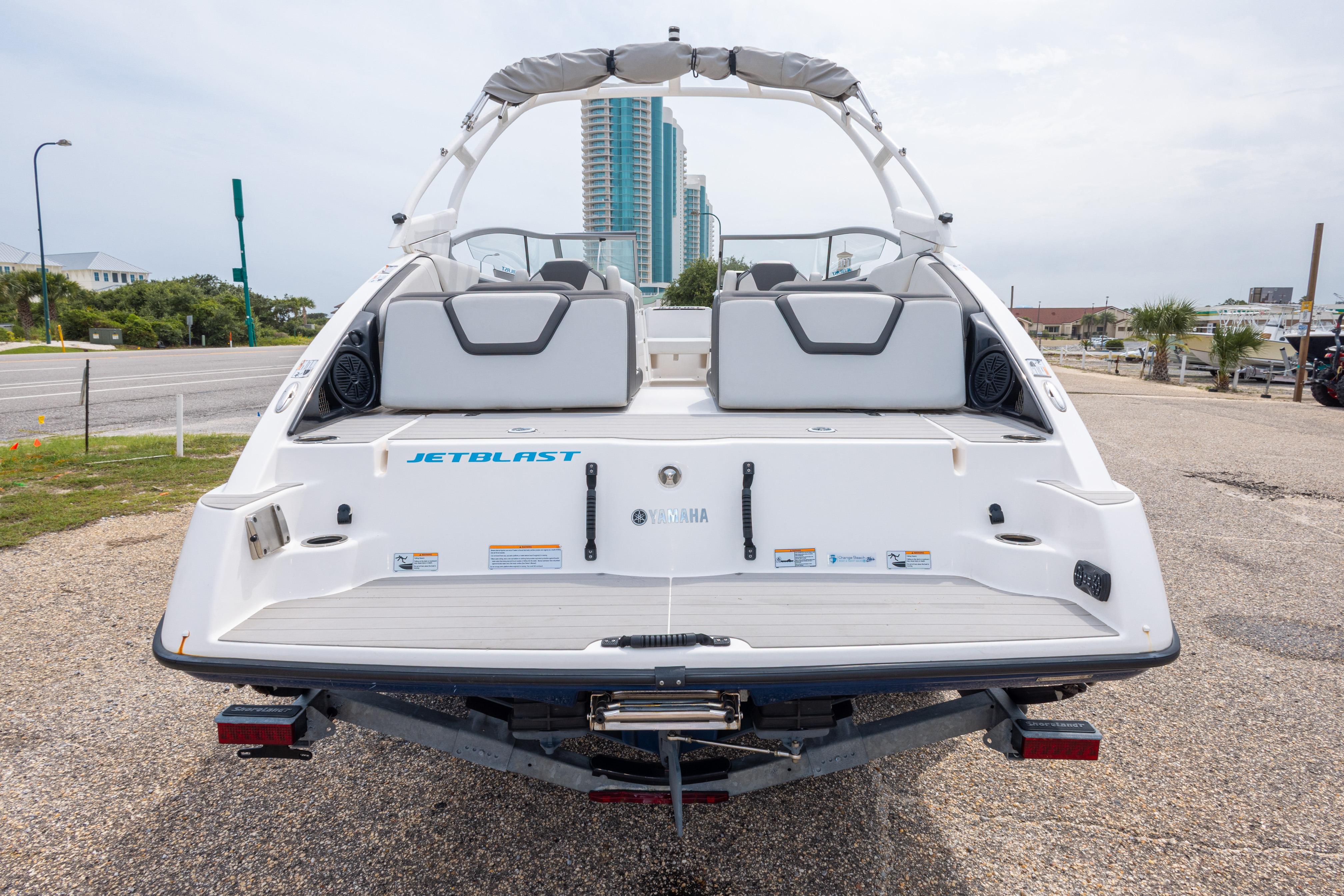 2021 Yamaha Boats AR250, rear view, parked on gravel, with cityscape background.