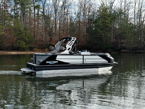 2025 Montara Surf Boss 2.0 25 boat on a calm lake with forest backdrop.