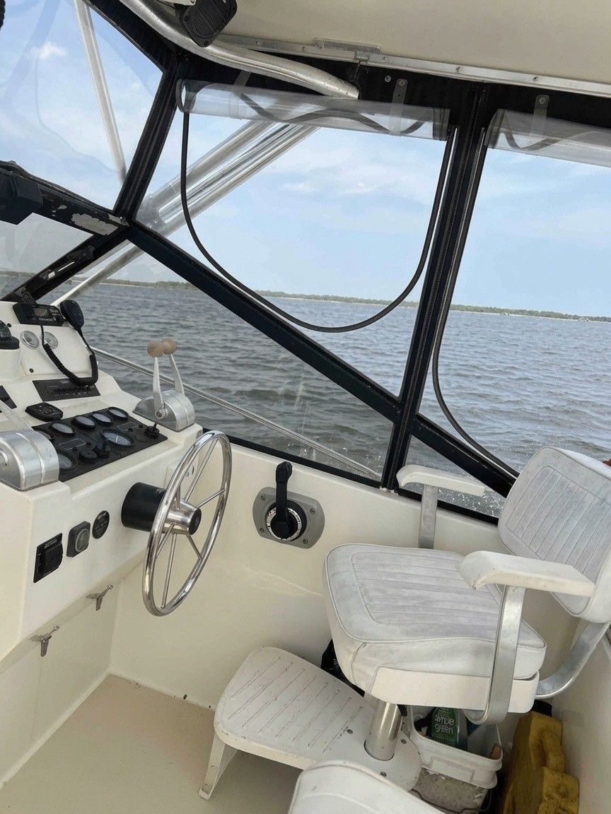 The cockpit of a 2003 Carolina Classic 28 with steering wheel, instruments, and a white seat.