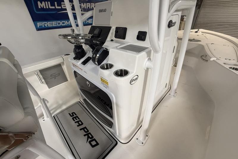 2026 Sea Pro 250 Bay boat interior with steering console and cup holders.