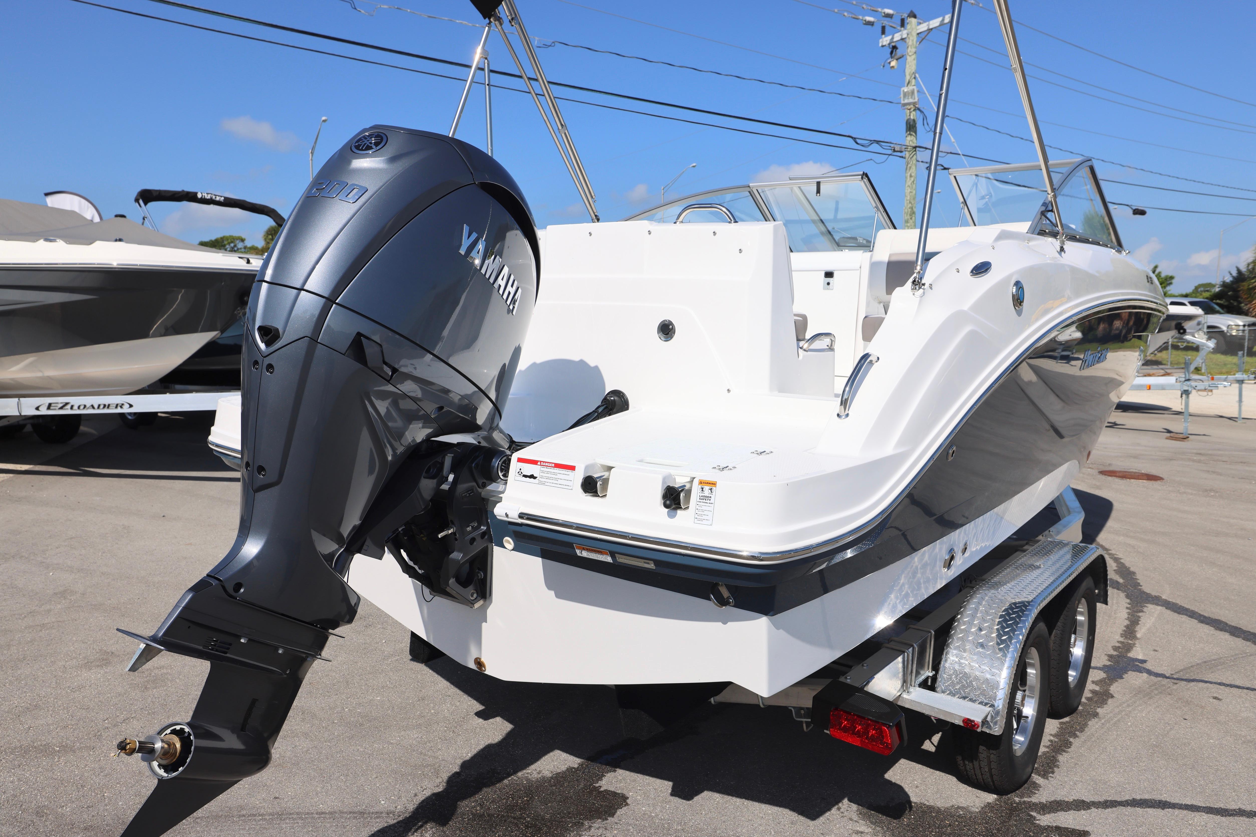 2026 Hurricane SunDeck 235 OB boat with Yamaha outboard motor on trailer.