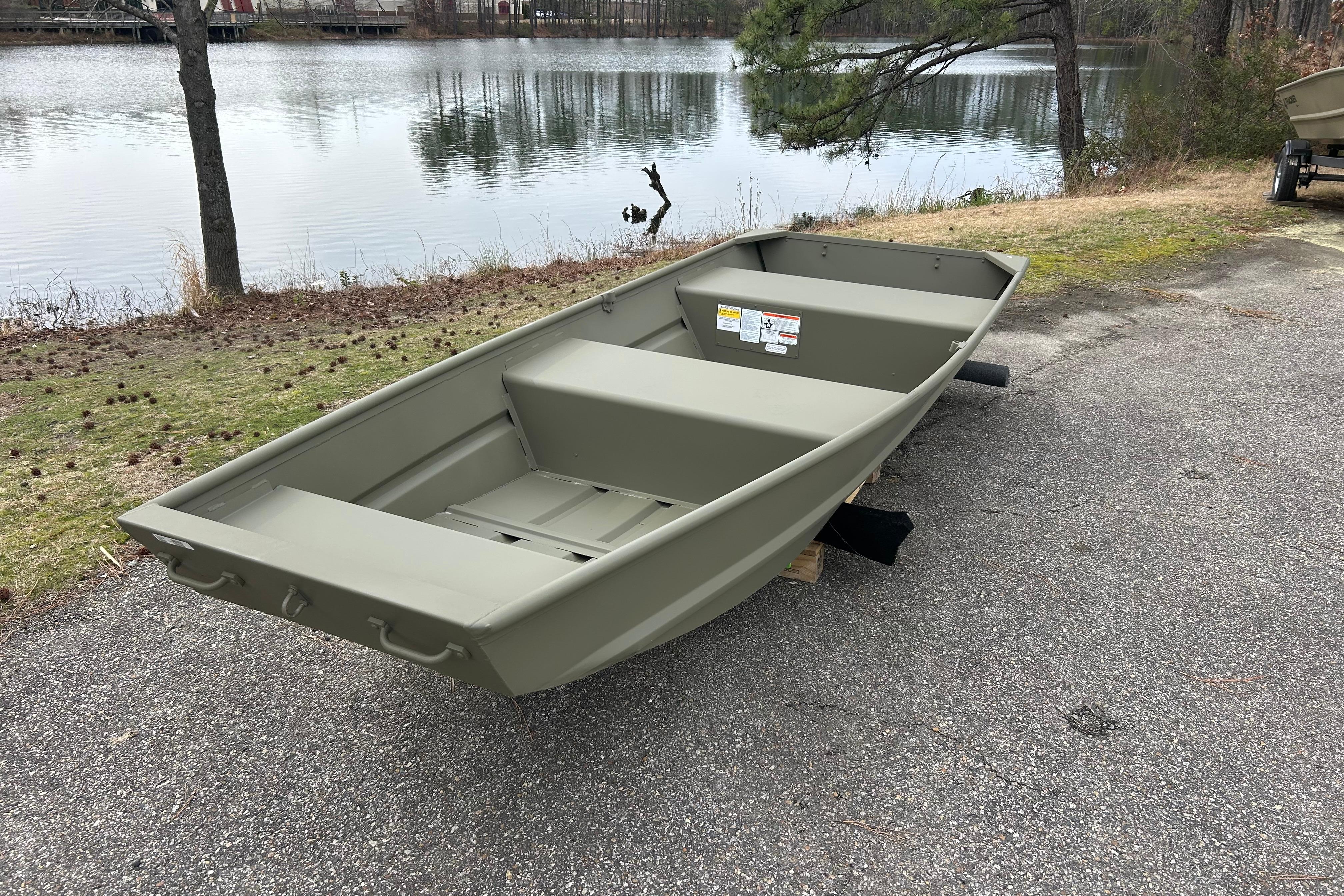 2026 Tracker Grizzly 12 Jon boat by a serene lakeside.