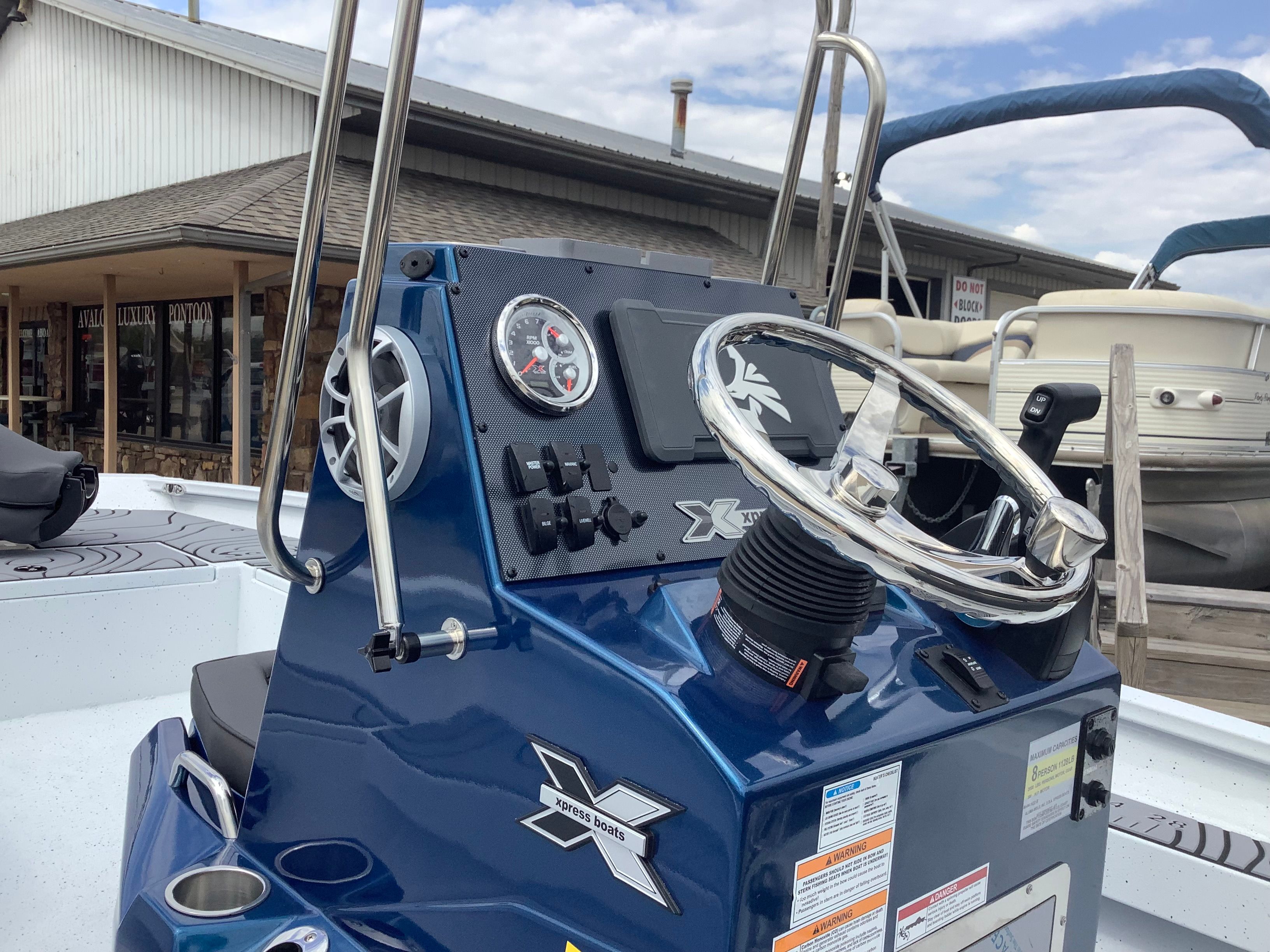 2026 Xpress H22B Bay boat console with shiny steering wheel.
