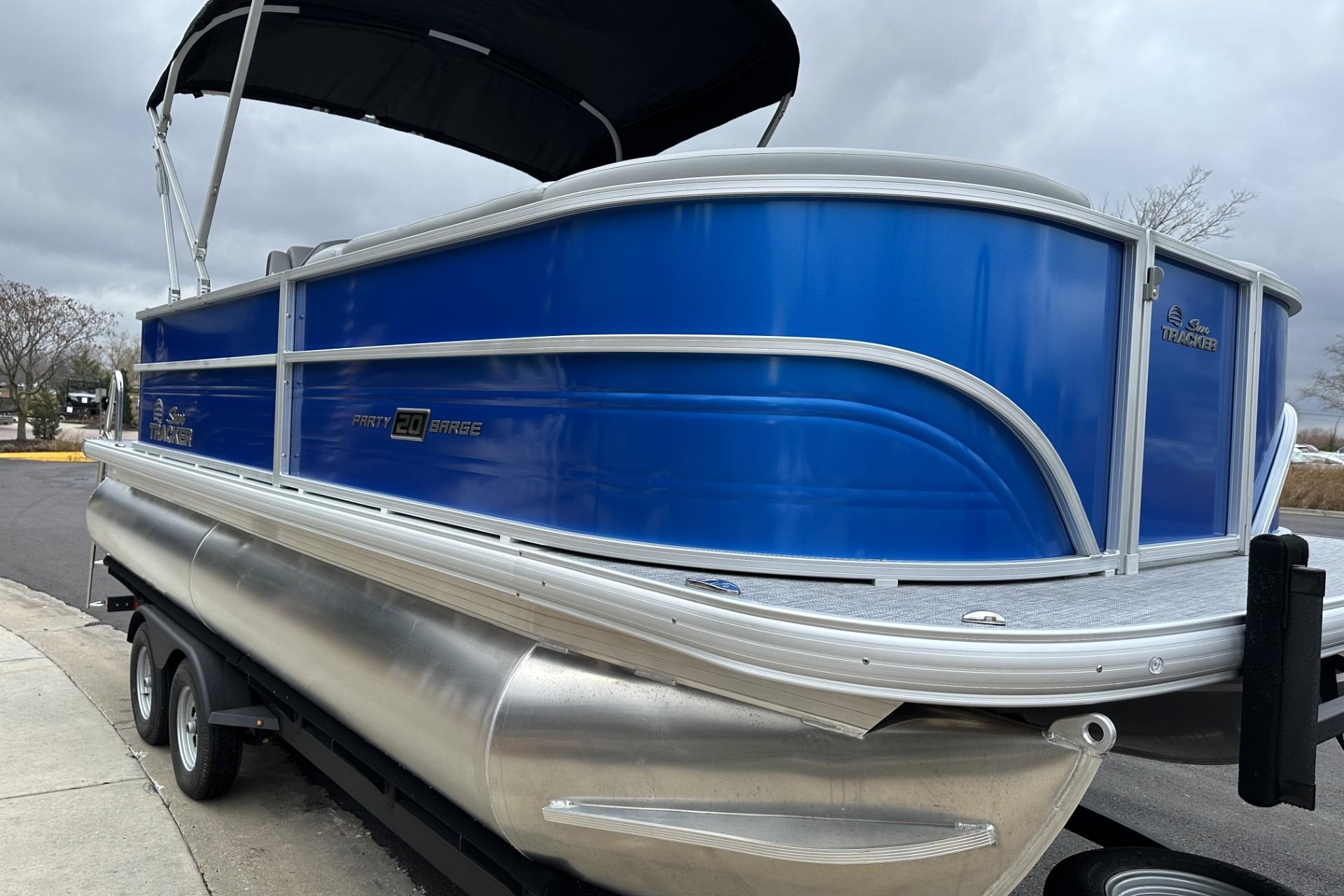 2026 Sun Tracker Party Barge 20 DLX pontoon boat with blue exterior on trailer.