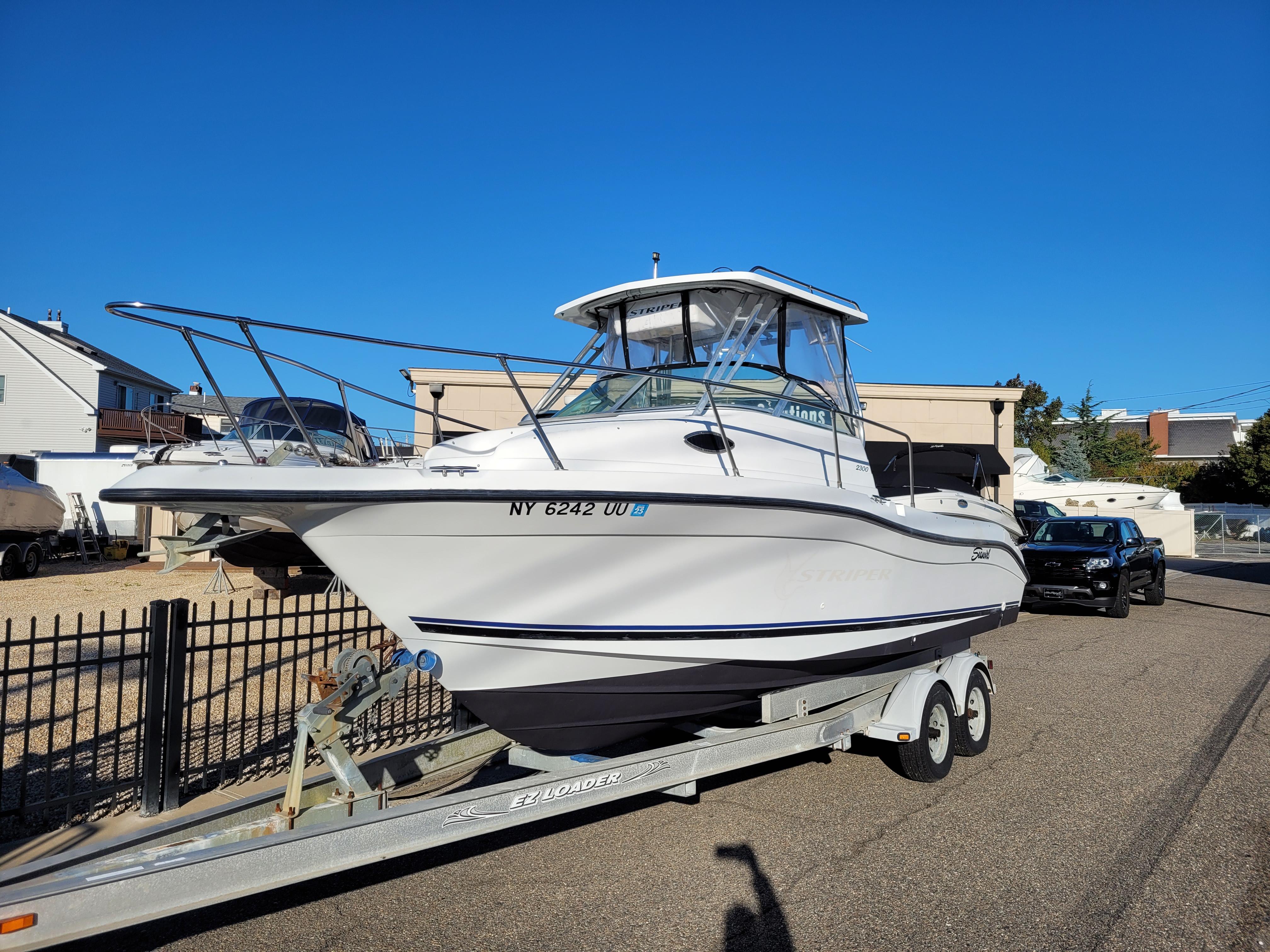 2000 Seaswirl Striper 2300 Walkaround OB on trailer, parked outdoors.