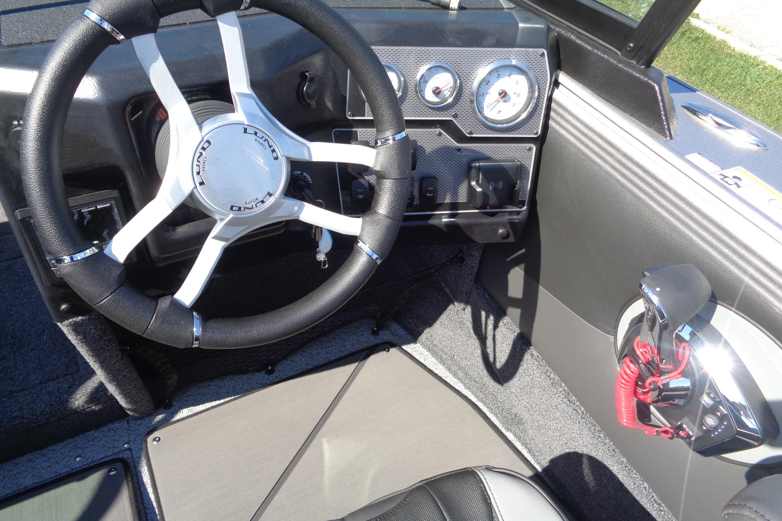 Interior of 2026 Lund 1975 Tyee boat with steering wheel and control panel.