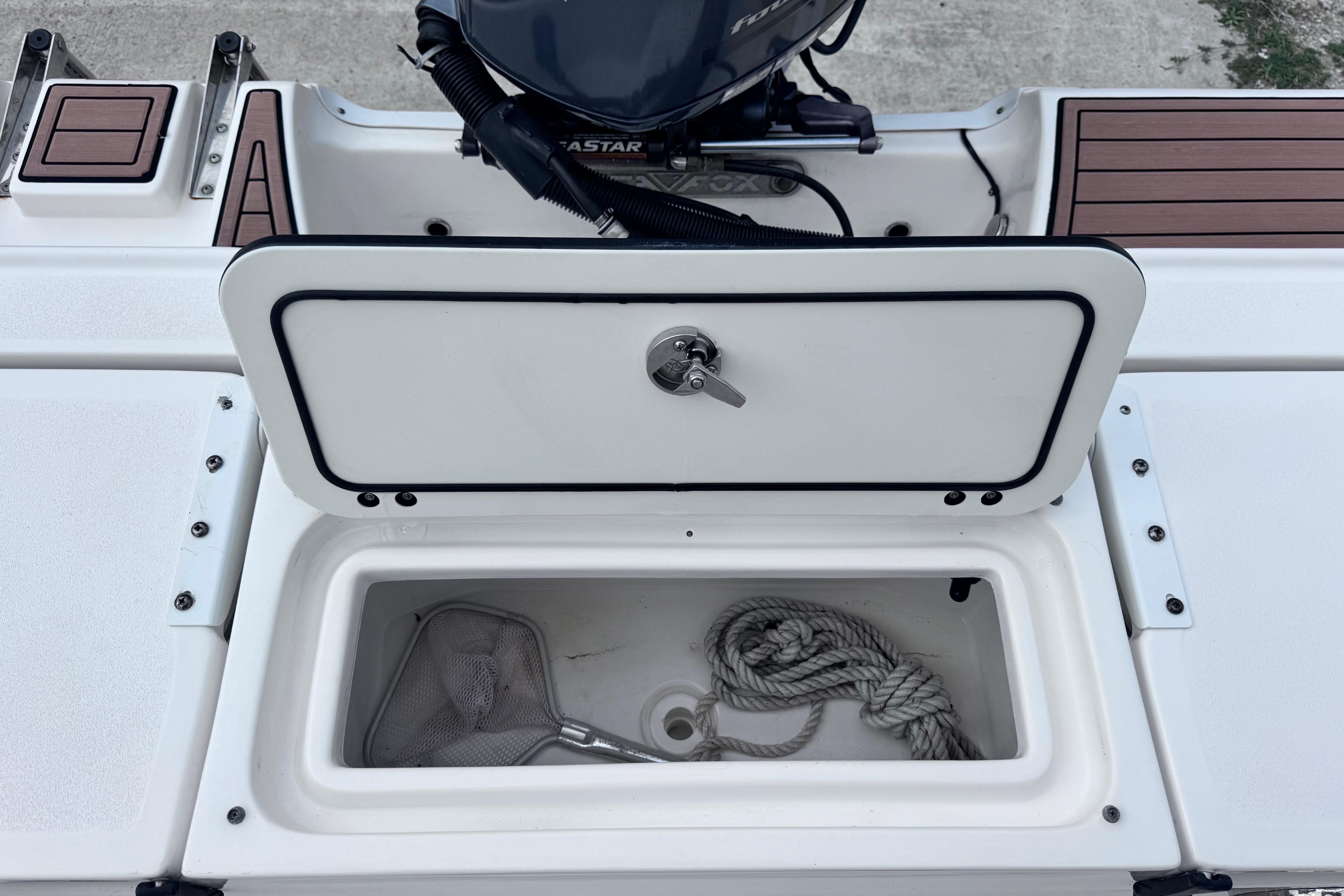 Open storage compartment on a 2018 Sea Fox 206 Commander boat with rope and net.