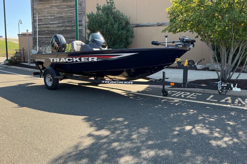 2026 Tracker Super Guide V-16 SC boat on trailer, parked outdoors.
