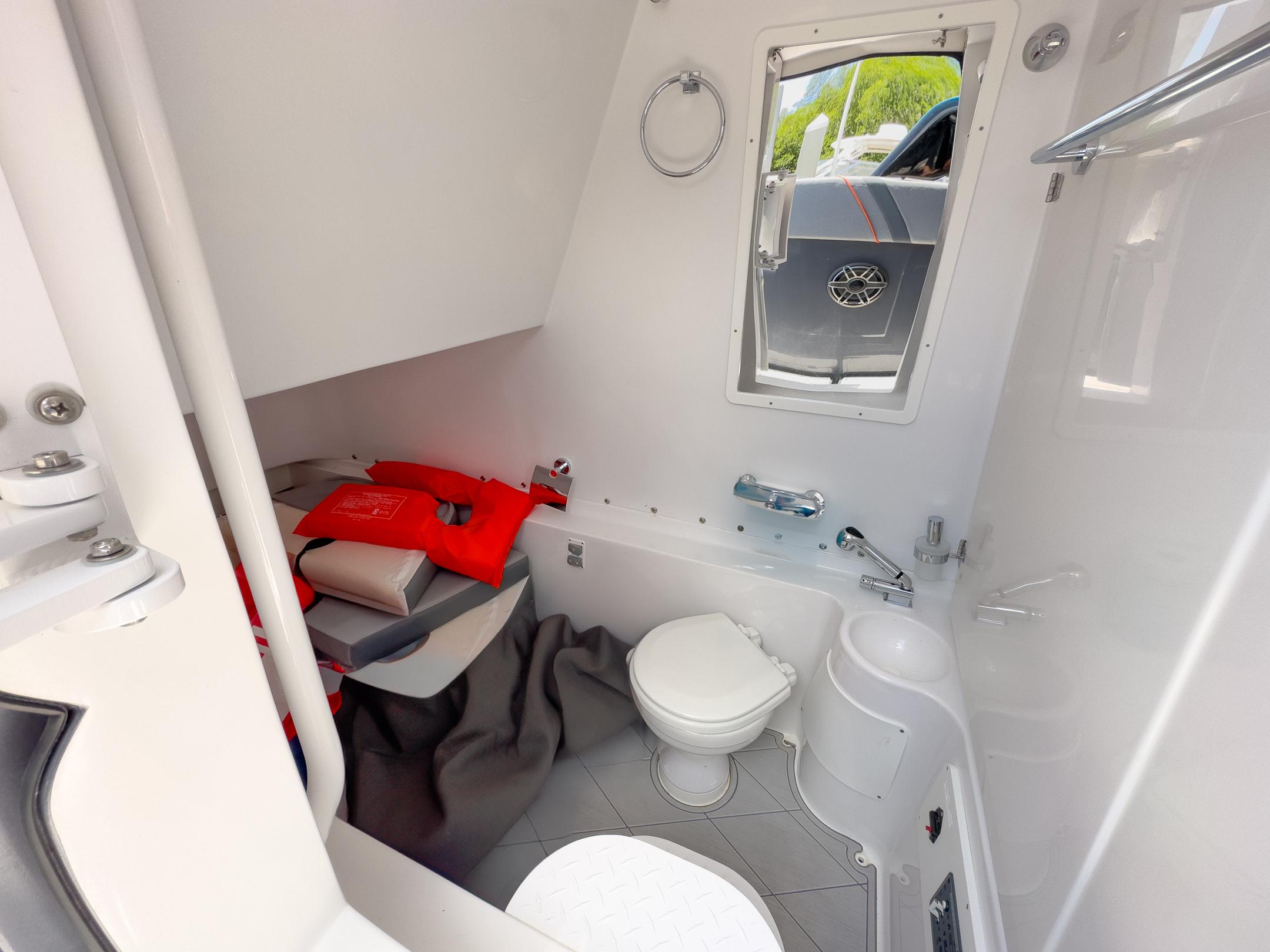 2022 Midnight Express 37' Open boat interior bathroom with life jackets and modern amenities.